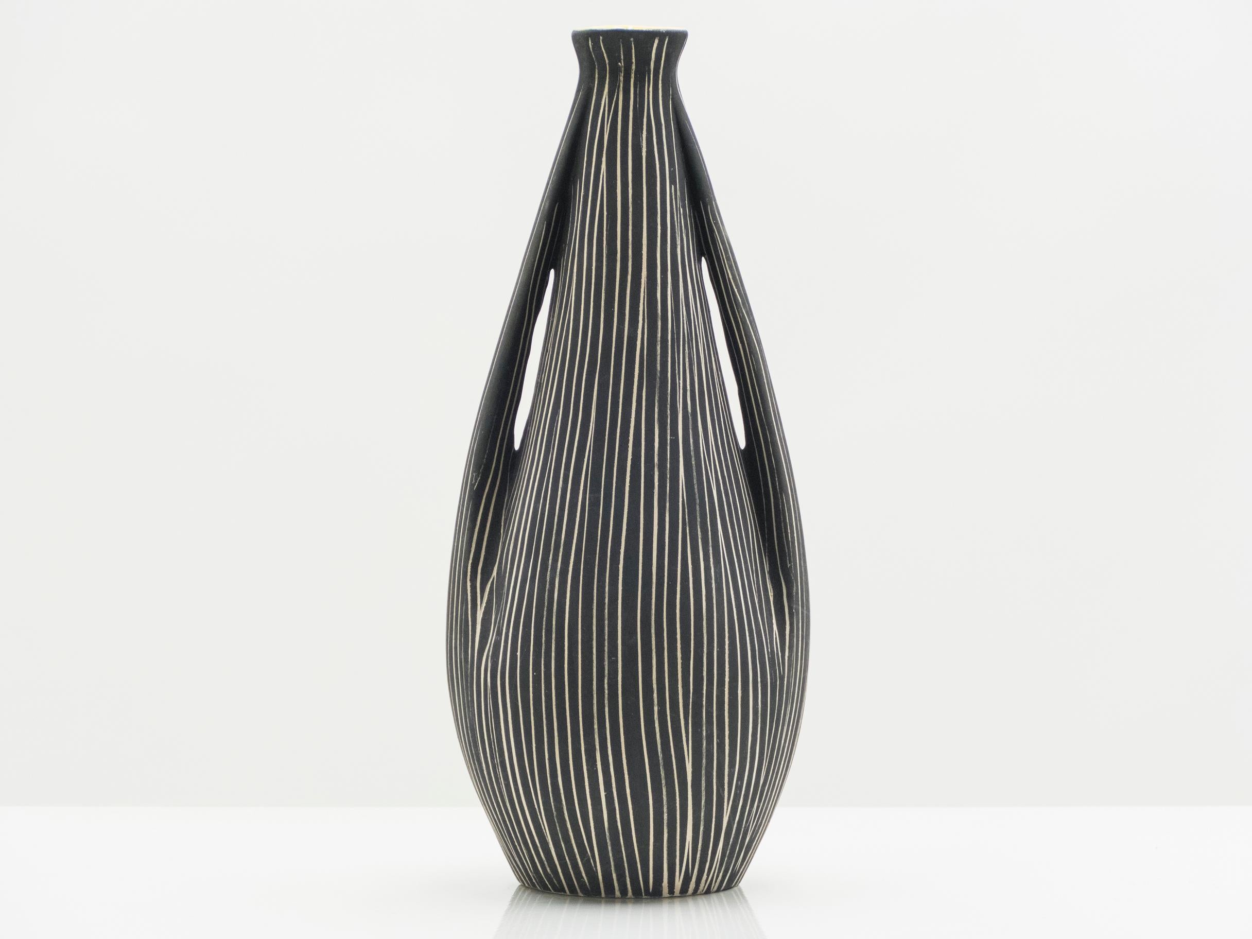 This curved Italian satin black striped ceramic and yellow enamel vase would be beautiful in any space. It was created in the early 1960s by an unknown Italian ceramicist s. With a feminine striped body and a rich yellow neck, this vase is really