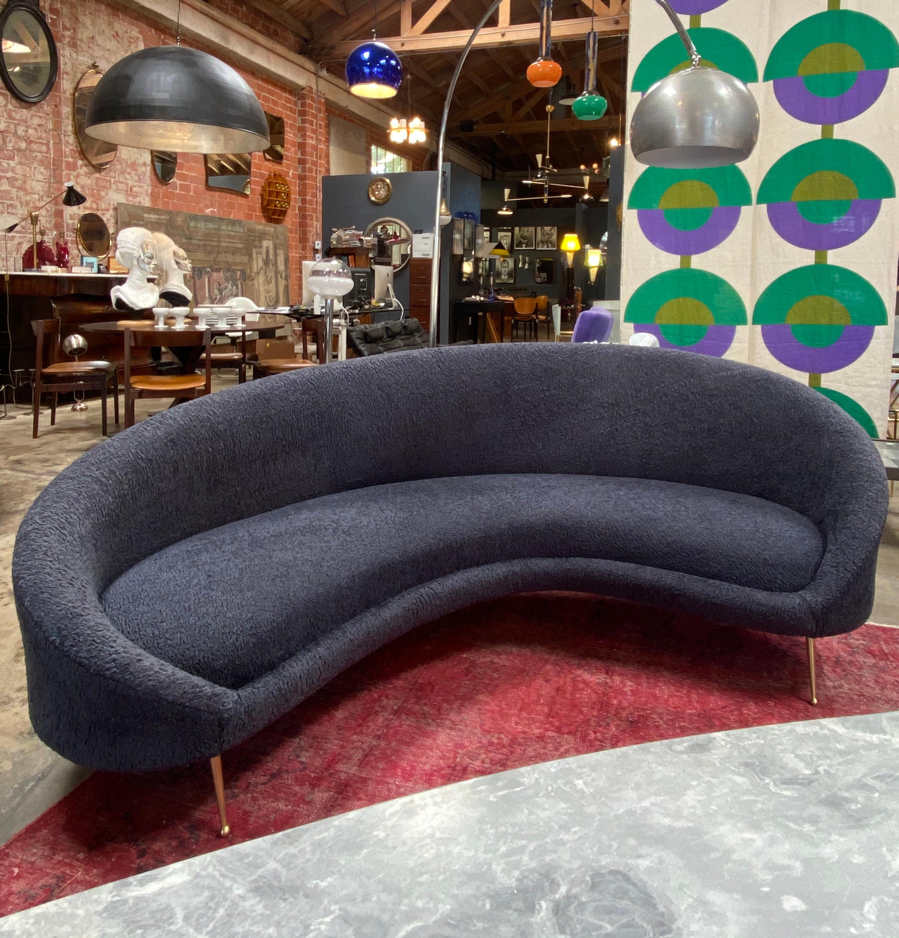 Beautiful from every angle, this large and comfortable midcentury Italian curved sofa has tapered brass legs and luxurious Italian blue wool velvet upholstery sofa is very well made, substantial and comfortable with beautiful lines. Sofa dates 1950s.