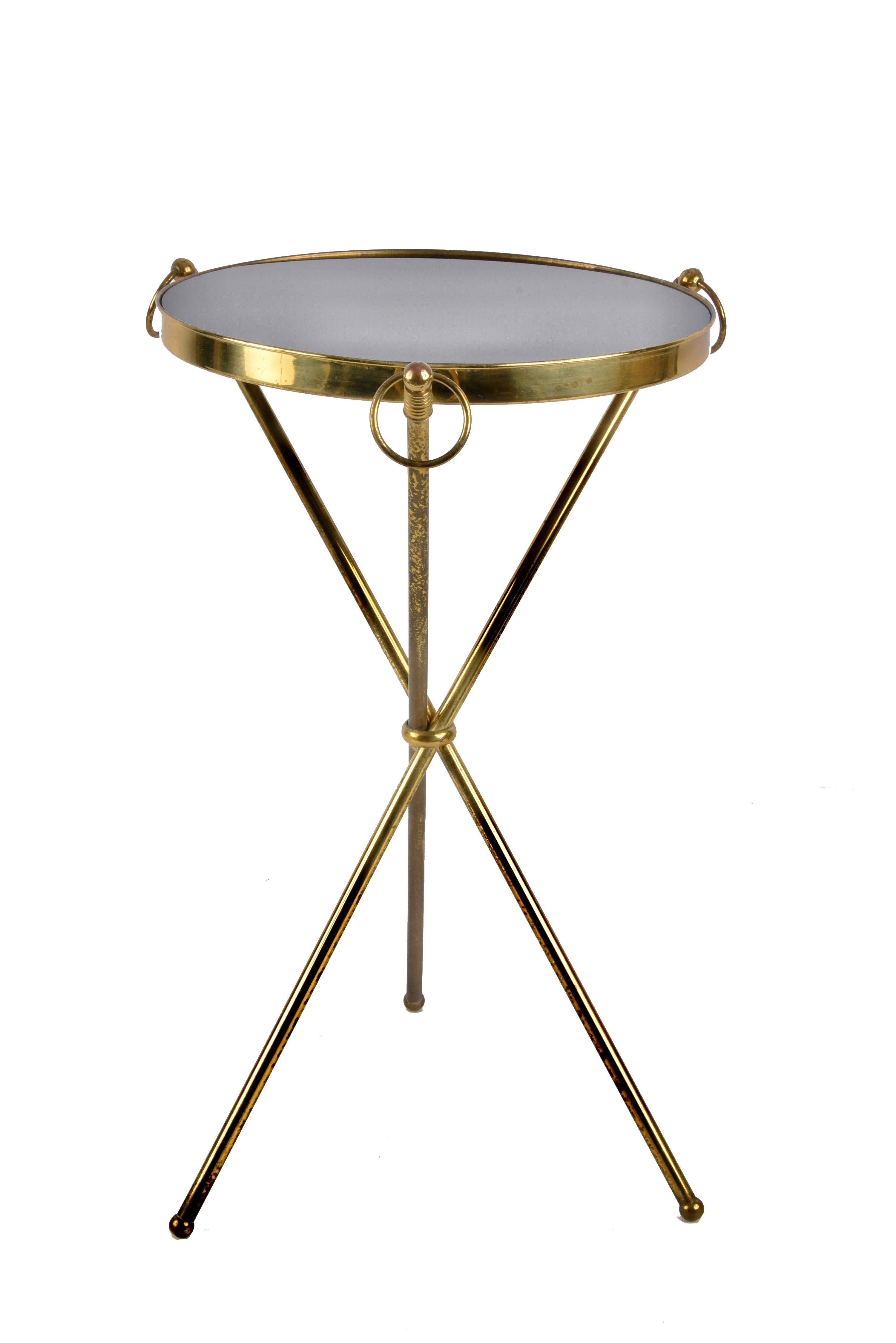 Amazing midcentury brass and glass round side table with tripod structure. This outstanding piece was designed in Italy during the 1950s.

The brass structure with three legs, combined with a black glass top is just breathtaking. Another iconic