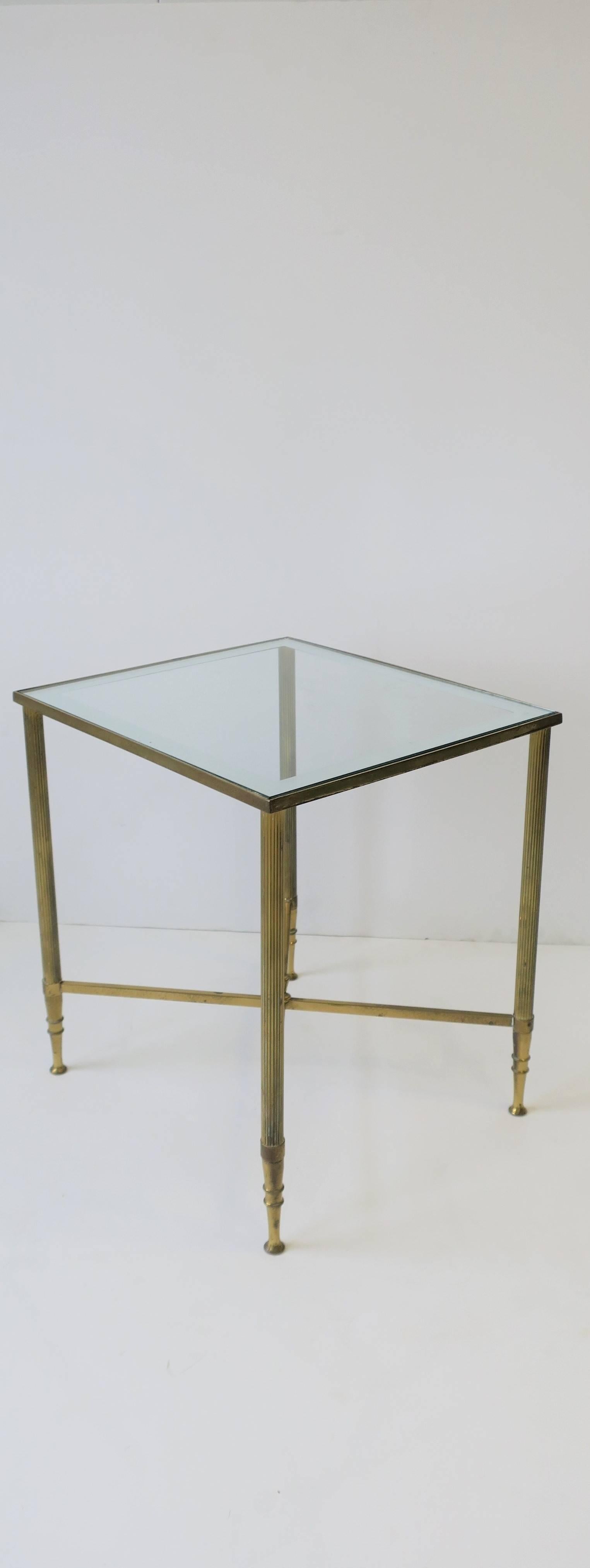 A small and beautiful Italian brass and glass side table, drinks table. or small end table, in the Directoire style after design house Maison Jansen, mid-20th century, circa 1960s, Italy. Table has an inset glass top with mirrored edge and stretcher