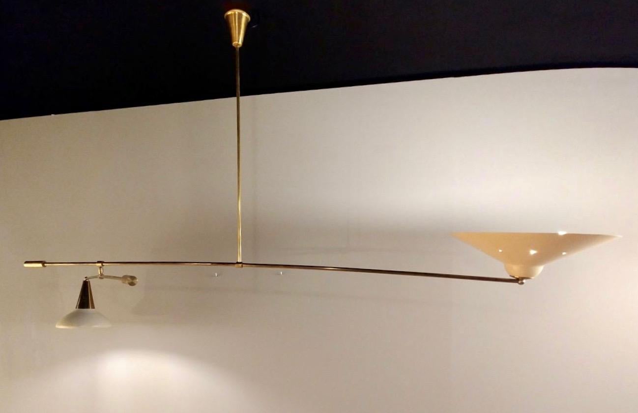 Midcentury Italian brass and lacquered metal chandelier with two articulate arms.
Brass stem with two articulated arms with two shades.
Size is flexible depending on the adjustment of the arm, which makes this light very versatile.
Very good