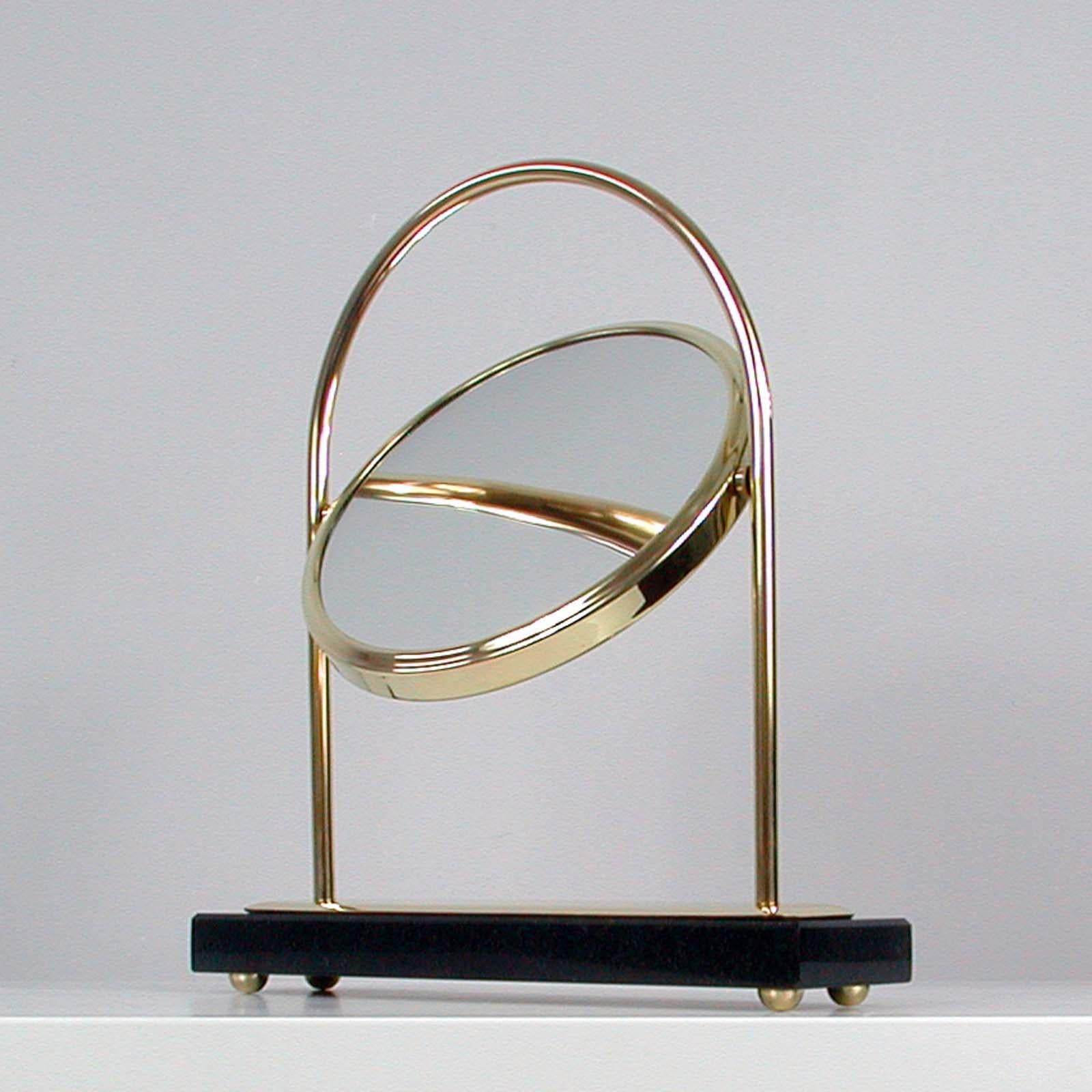 This elegant modernist table or vanity mirror was designed and manufactured in Italy in the 1950s. The mirror has got a brass frame and a black marble base (the base and the frame have been professionally polished).

The mirror has got a normal