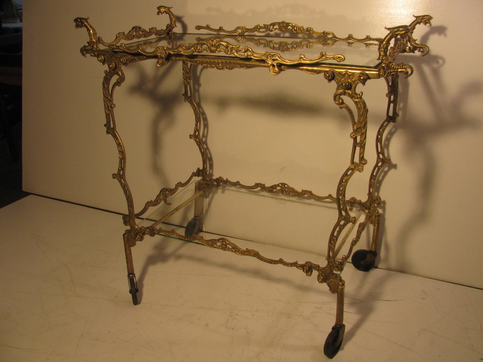 Fabulous mid century circa 1950 bar cart in figural brass. Each piece, and there are many which are all finely hand cast out of solid brass. Handles are sea serpents and in excellent condition.