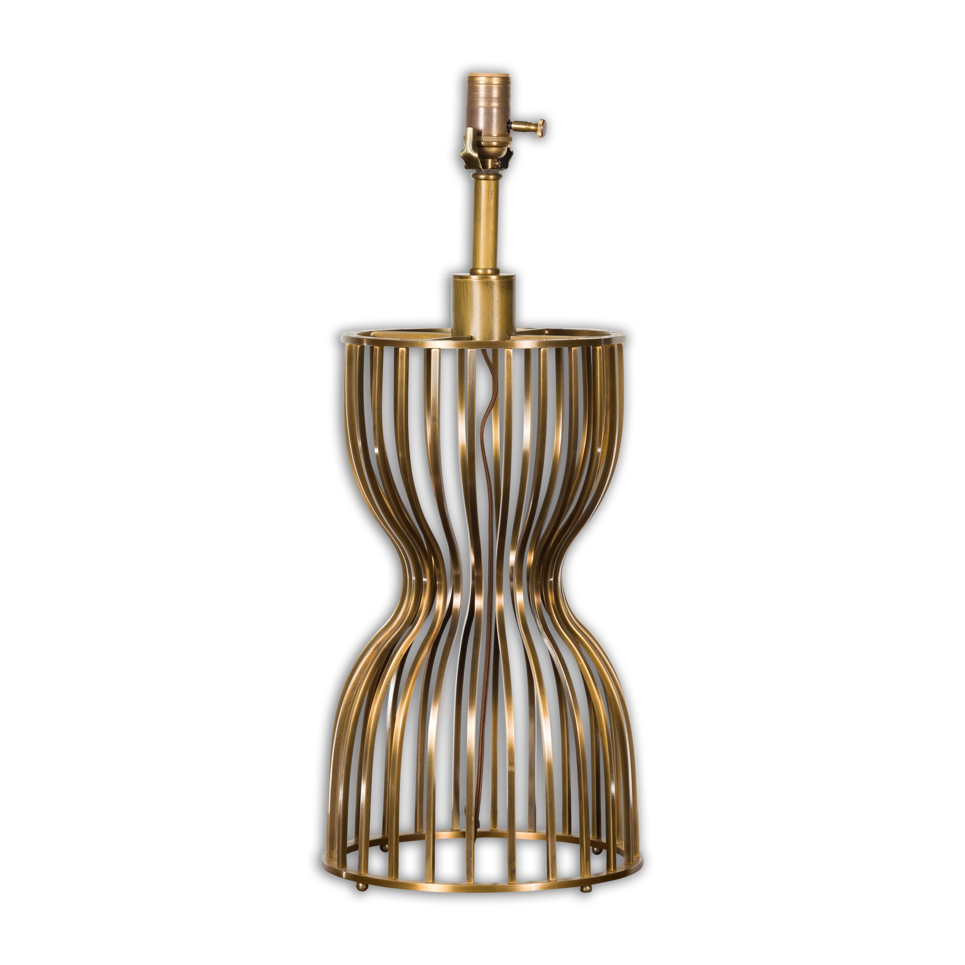 A Midcentury Modern Italian Brass hourglass shaped table lamp with single socket and newly and professionally rewired for the US. Radiating Midcentury Modern elegance, this Italian Brass hourglass-shaped table lamp offers both form and