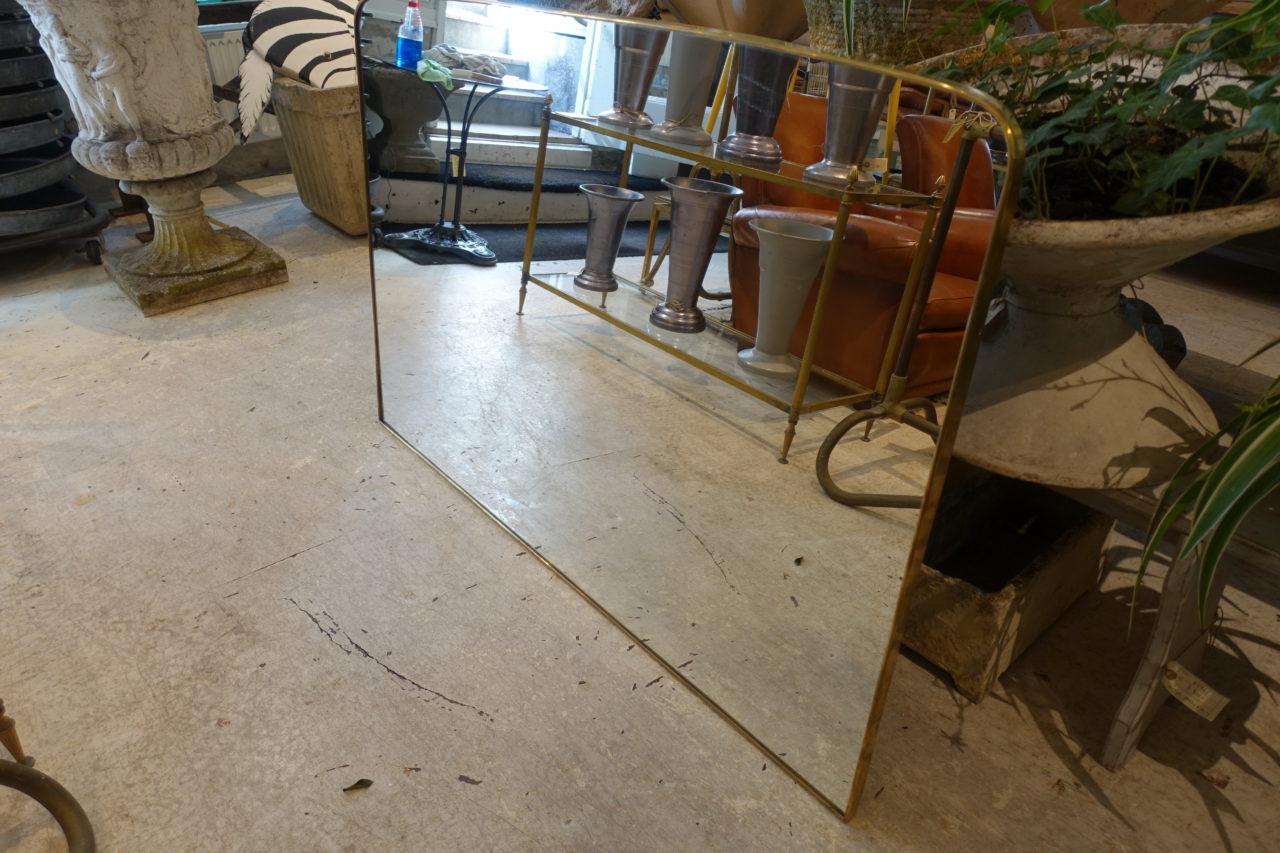 Stunning vintage Italian brass framed mirror, from the 1950s. Original glass and gorgeous curving profile. Can be attributed style wise to the designer Gio Ponti. Wall hanging attachments on the back.