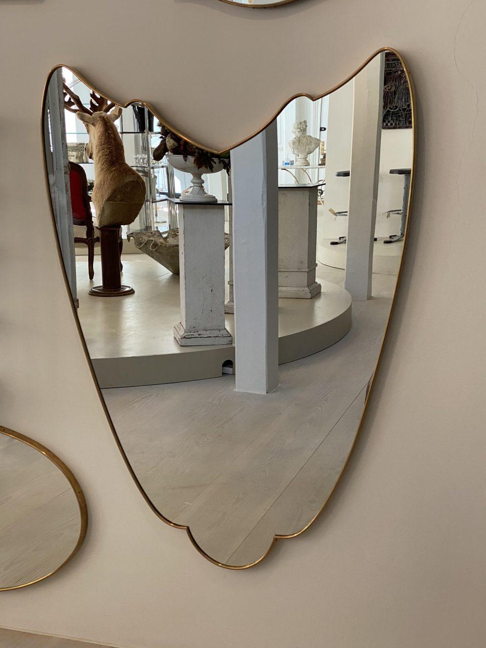 Smart and sleek and rarely found Italian brass mirror from the 1950s, with a slim frame and stunning eye catching free expression form. The mirror glass is original and the mirror is related stylistically to the midcentury designer Gio Ponti.

The