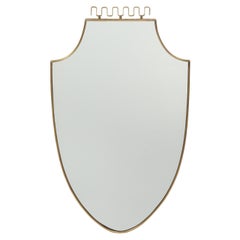 Espejo italiano de mediados de siglo en forma de escudo de latón, años 50