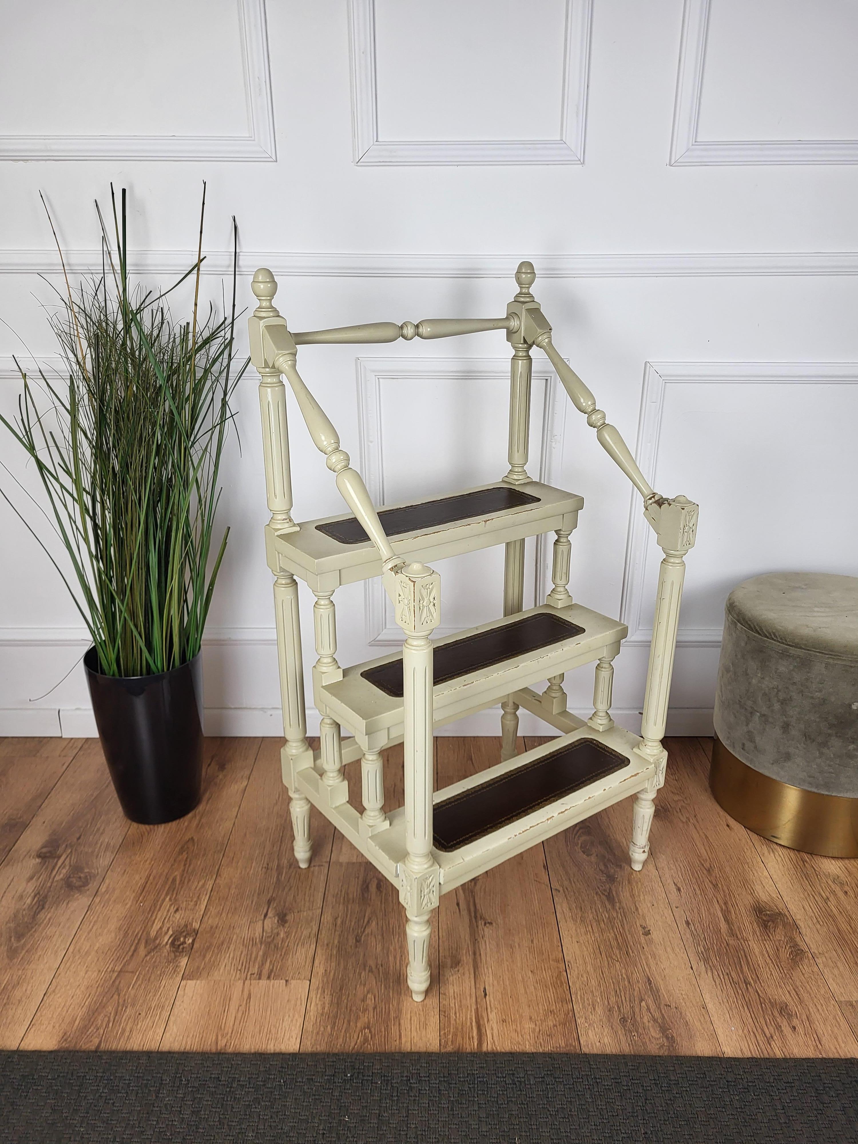 Beautiful Italian carved walnut wood step ladder with four stairs and nicely carved details and decorated structure. Each step is upholstered with dark leather and golden classic frame. Versatile and practical, the elegant library essential is in