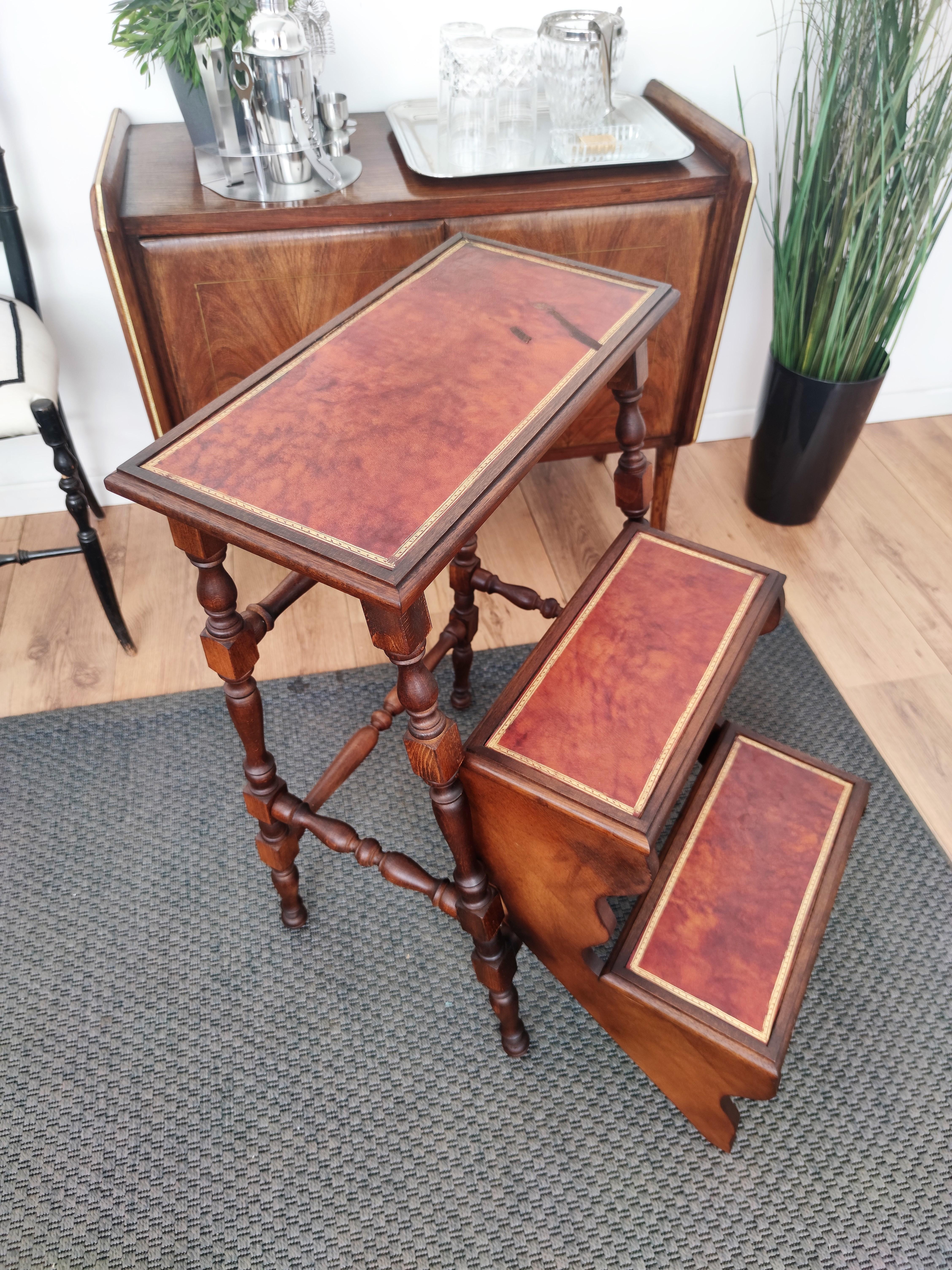 Beautiful Italian carved walnut wood foldable step ladder with three stairs with great twisted turned legs. Each step is upholstered with the original red leather decorated with gold tooling motifs. Versatile and practical, the elegant library