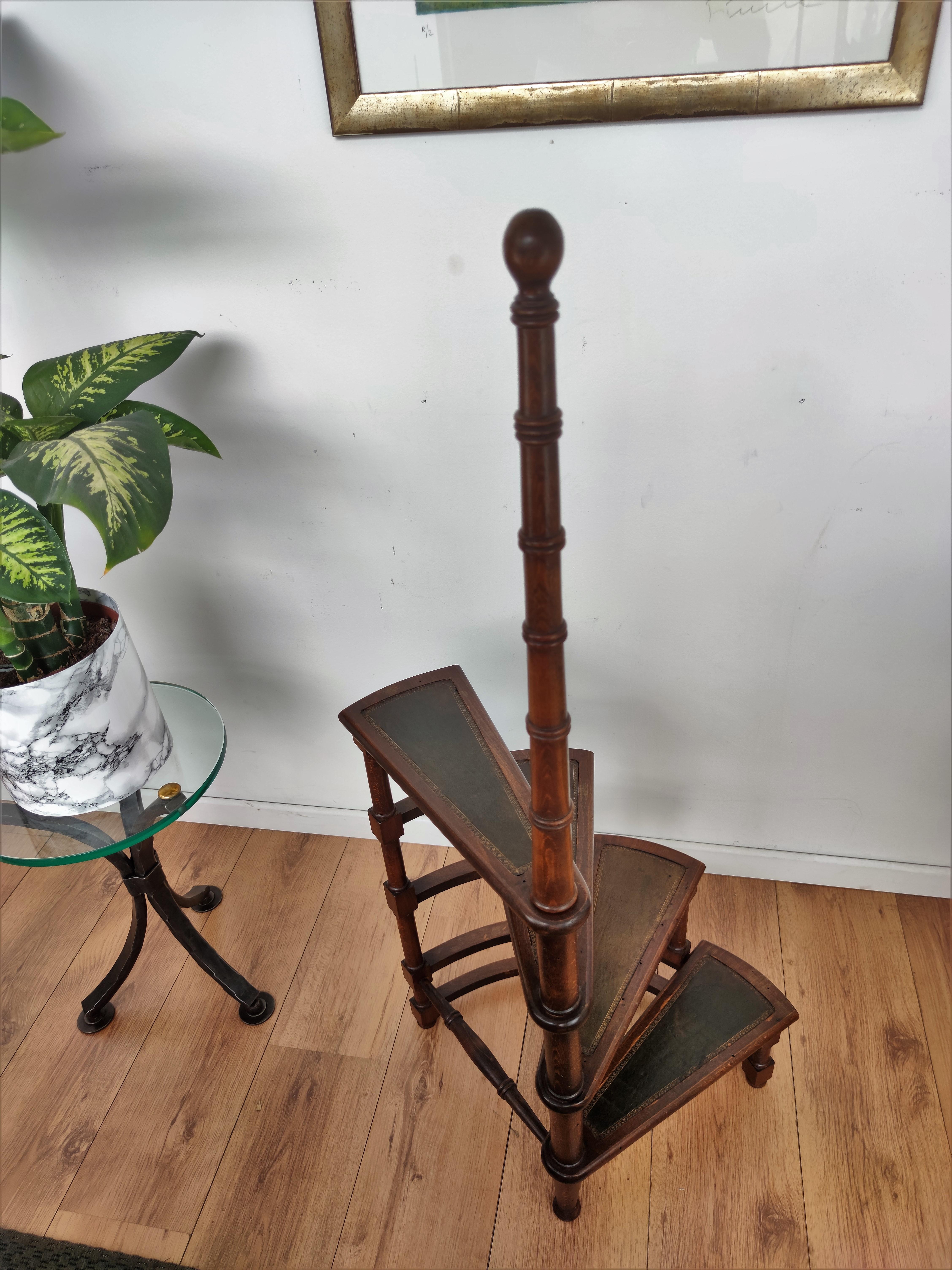 Beautiful Italian carved walnut wood tall circular step ladder with four stairs rolled around a turned, central post embellished with a decorative finial. Each step is upholstered with dark green leather. Versatile and practical, the elegant library