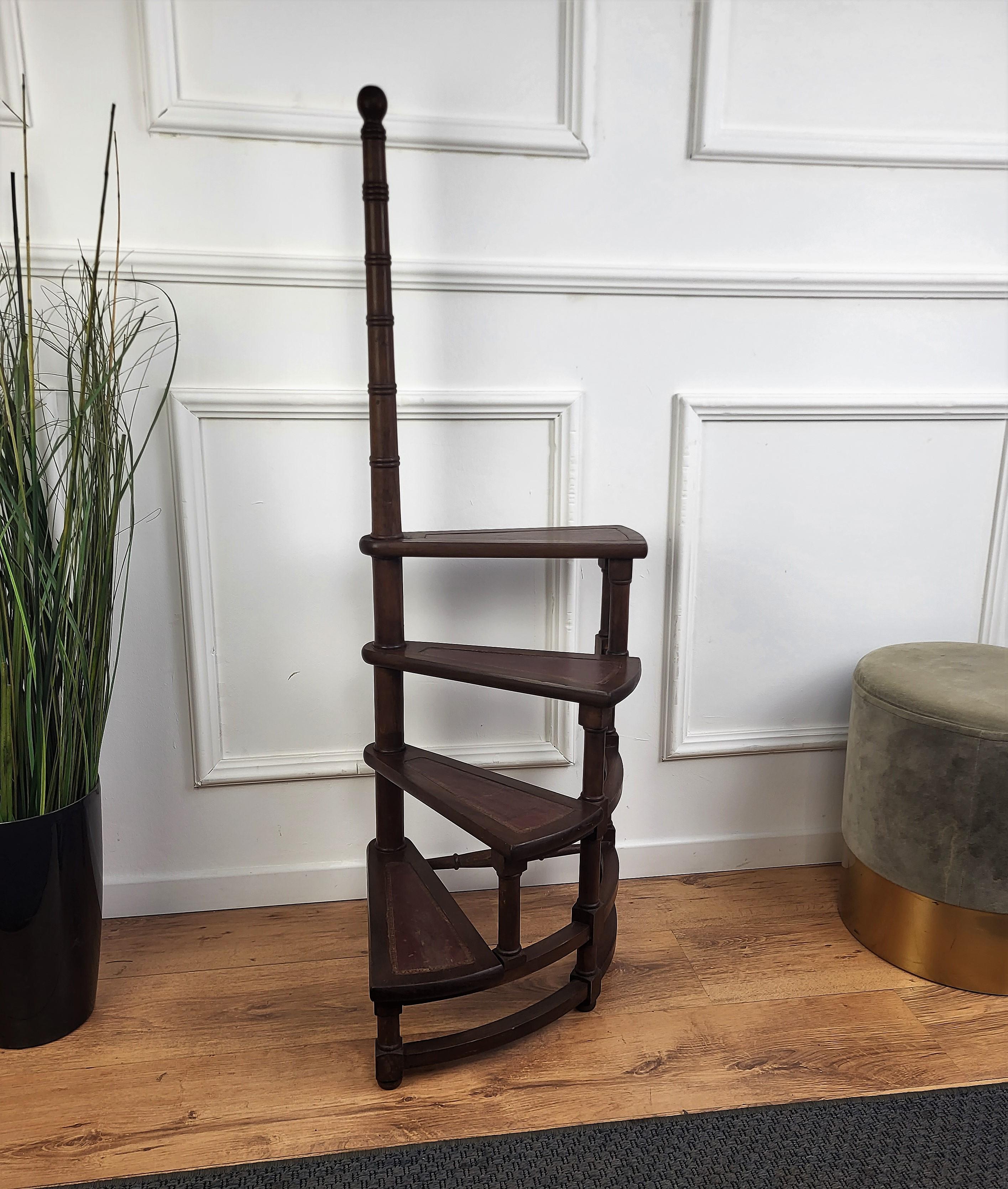 Beautiful Italian carved walnut wood tall circular step ladder with four stairs rolled around a turned, central post embellished with a decorative finial. Each step is upholstered with red leather and golden classic frame. Versatile and practical,