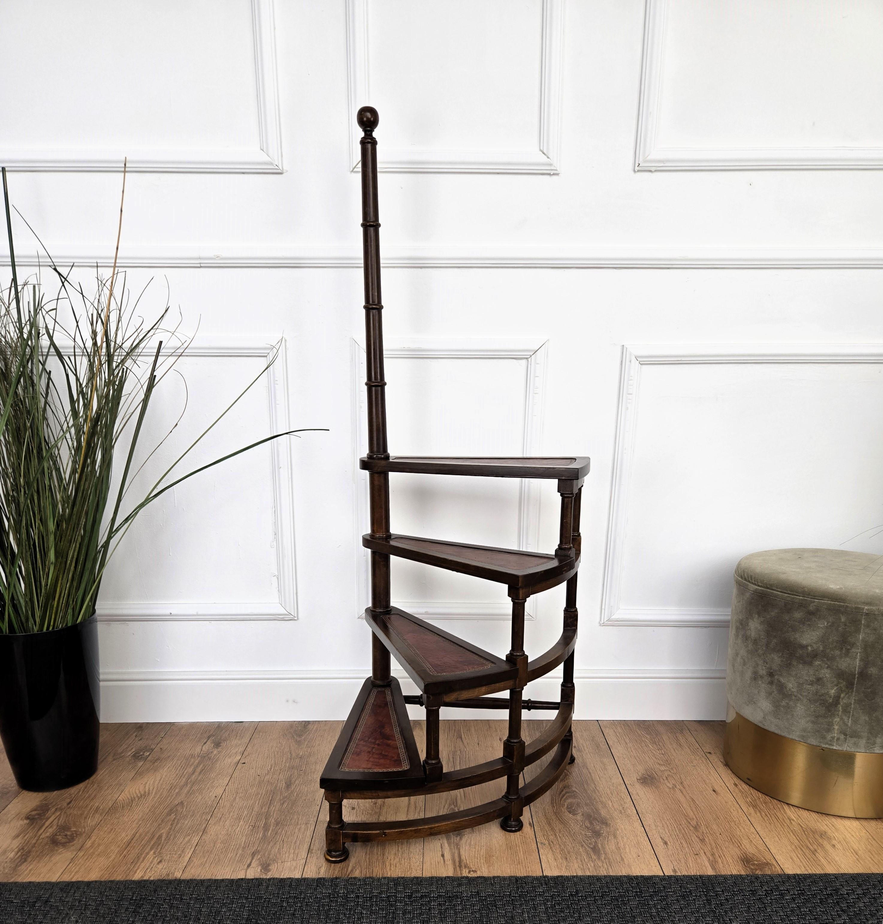 Beautiful Italian carved walnut wood circular step ladder with four stairs rolled around a turned, central pole with a decorative finial. Each step is upholstered with red leather and golden classic frame. Versatile and practical, the elegant