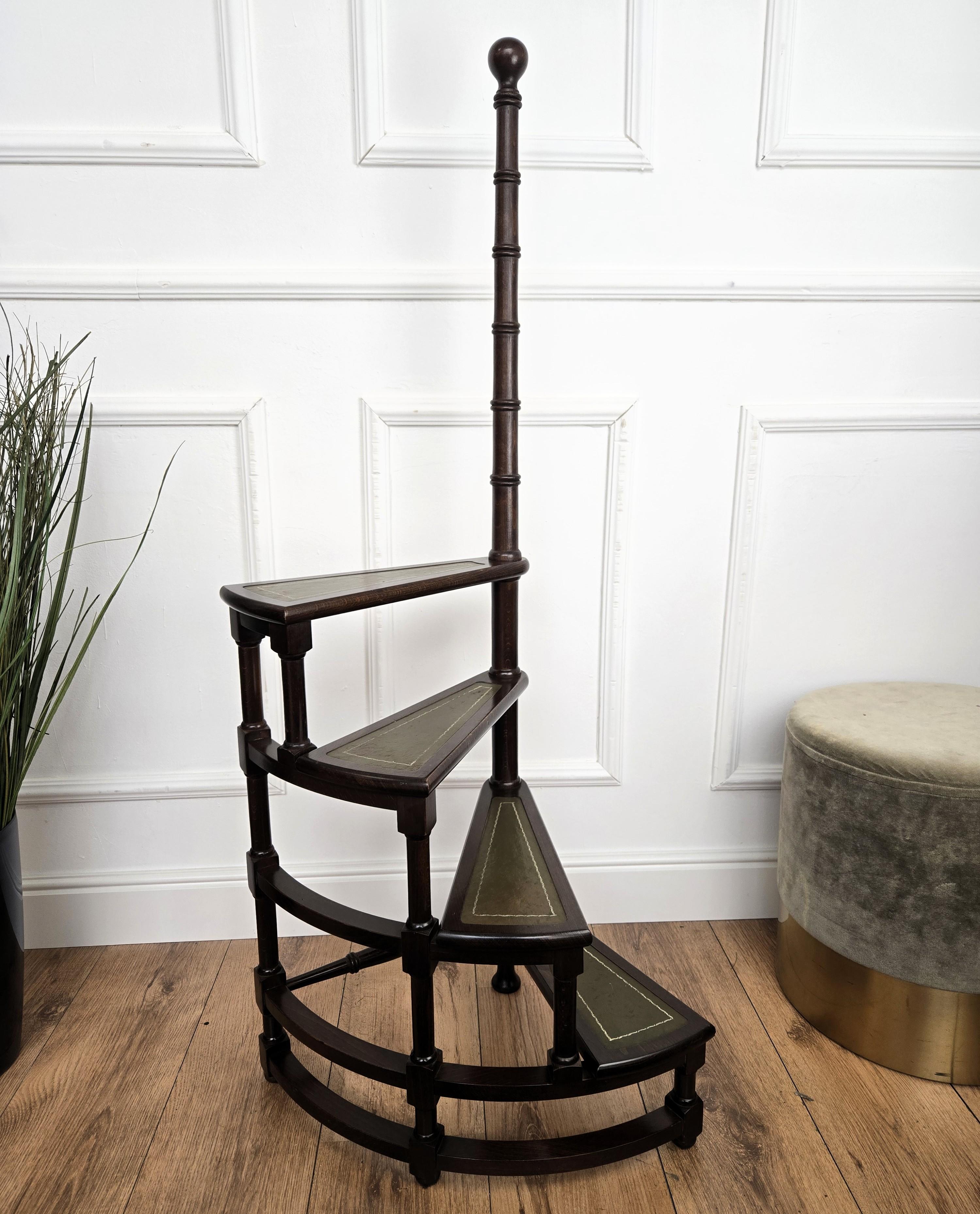 Magnifique escabeau circulaire italien en bois de noyer sculpté, avec quatre marches enroulées autour d'un poteau central tourné avec un épi de faîtage décoratif. Chaque marche est recouverte de cuir vert et d'un cadre classique doré. Polyvalente et