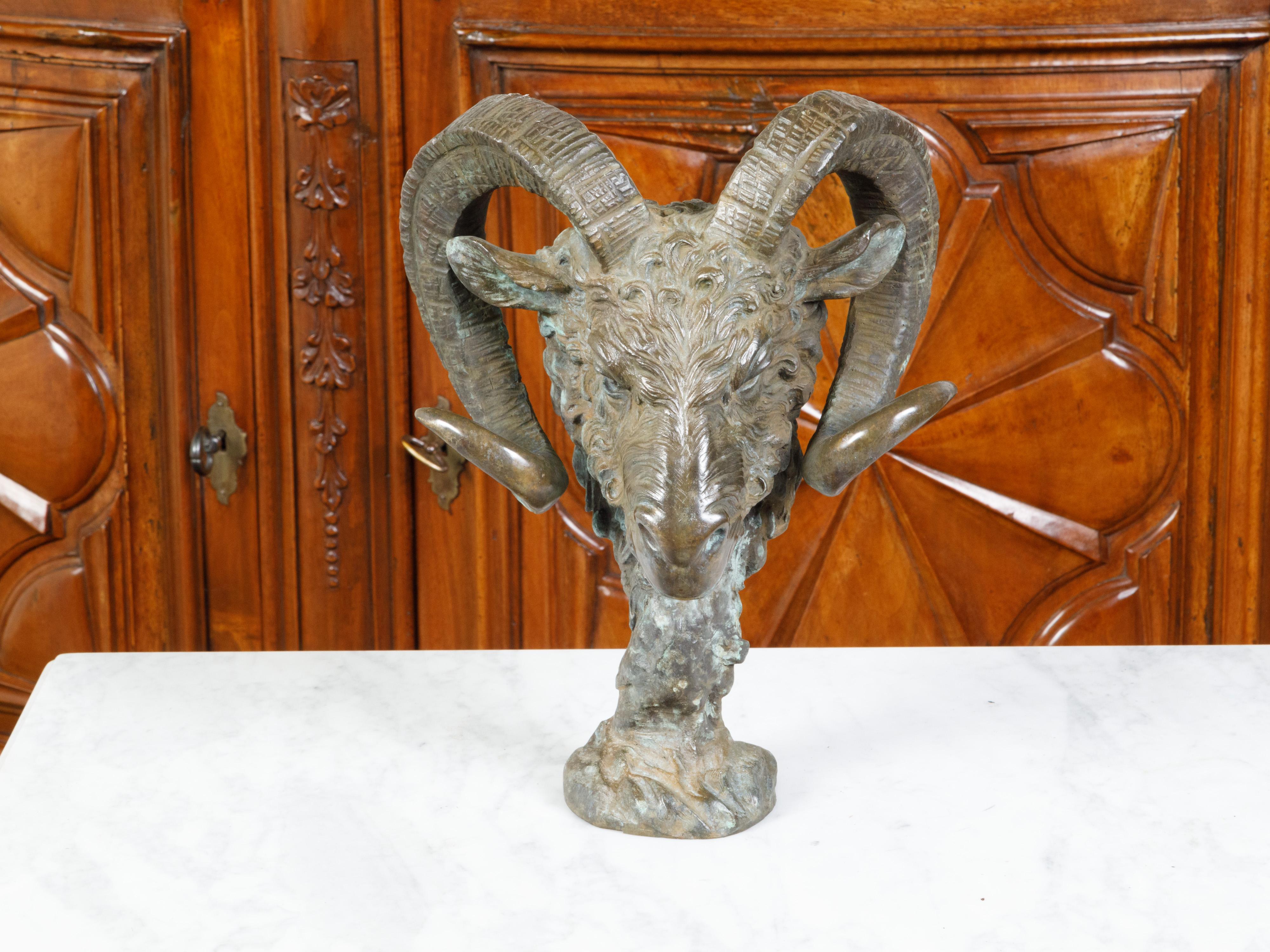 An Italian cast bronze sculpture from the mid 20th century, depicting a ram's head. Created in Italy during the Midcentury period, this bronze sculpture captures our attention with its striking depiction of a ram's head raised on a small base.