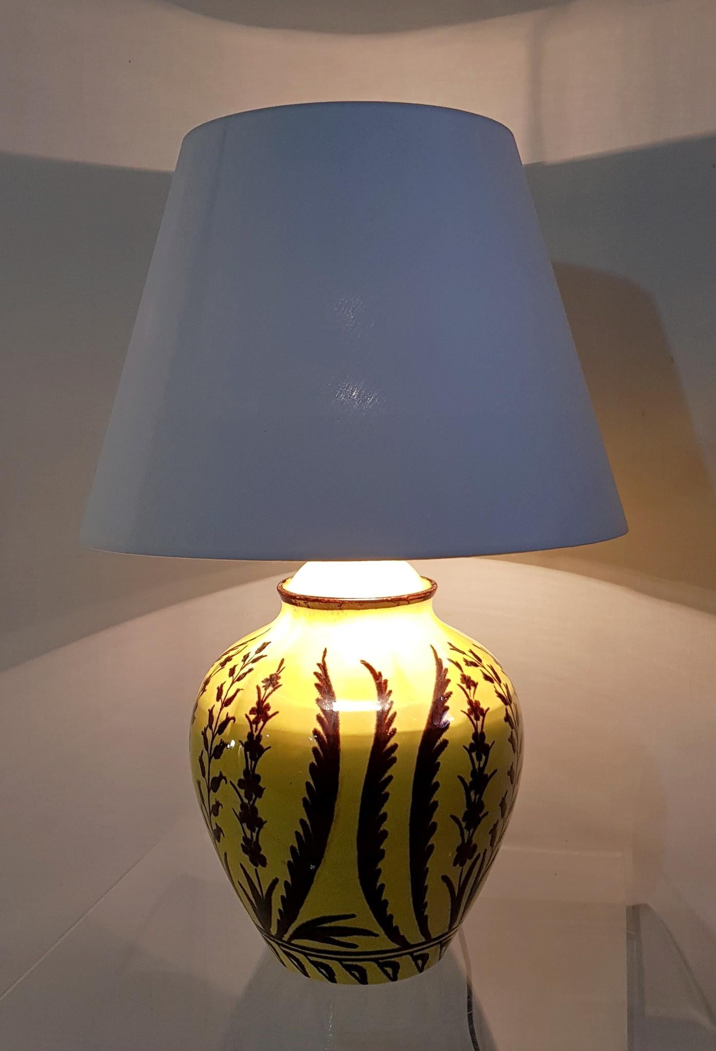 This lamp was handmade in Italy during the 1950s. It is marked at the base with a number and the production year (1957). It has a yellow base painted with different plants. In perfect condition and comes with a white lampshade.