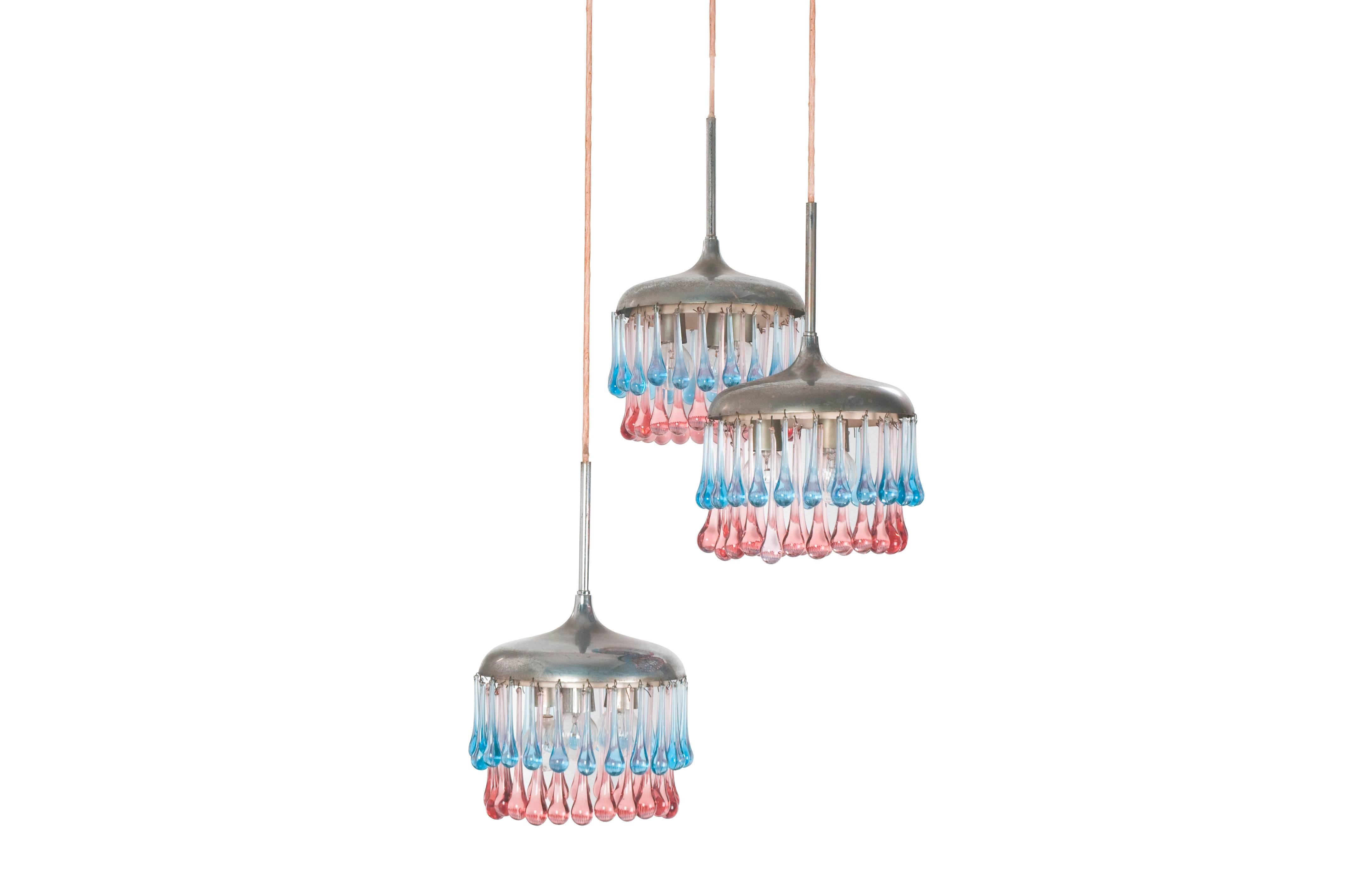 A rare and elegant pendant lamp produced by Stilnovo in the 1950s. It consists in 3 hanging shades with a Murano pendant decoration. Each shade shows three-light bulbs. The height is indicative and depends on the length of the electric cable which,