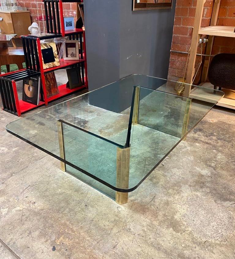 Wonderful coffee table with crystal glass top with thickness of 1 inch, the base of the table is made of the same crystal with brass finishes.
This amazing piece was produced in Italy during 1970s. 

This midcentury masterpiece of minimal design