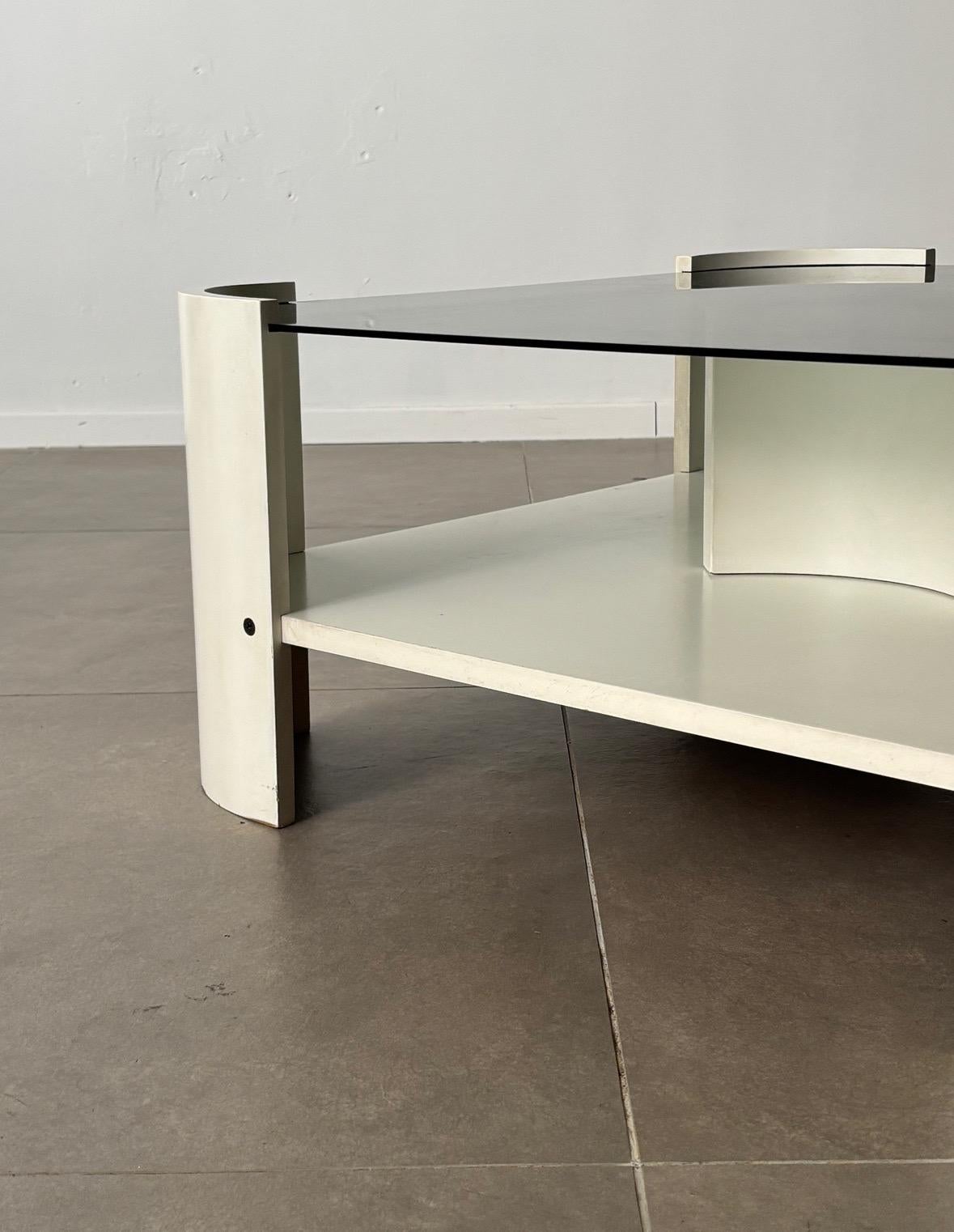 Dieser italienische Couchtisch aus der Mitte der 1970er Jahre zeigt ein elegantes Zusammenspiel von MATERIAL und Form. Der geschwungene, weiß lackierte Holzsockel strahlt eine elegante, skulpturale Qualität aus und verkörpert die raffinierte