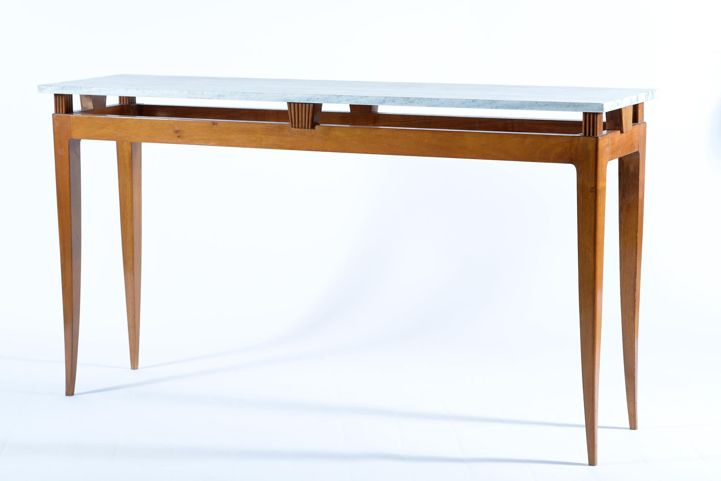Sculptured solid walnut four slender legs console table, finished on the back too, can be put against the wall or in a centre room or behind a sofa.
The top is in a Toscany marble called 