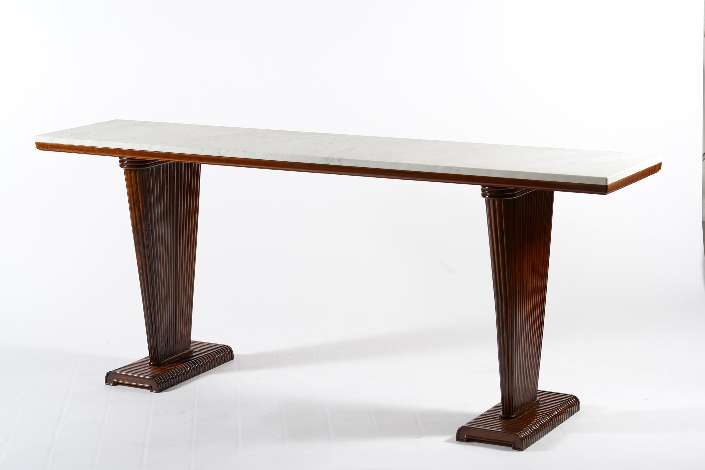 Console in walnut with two fluted side legs that narrow down, white marble top.
This midcentury elegant console is also finished behind and can be put in the center of a room or juxtaposed to a wall or behind a sofa.
Florence, Italy, 1940.
 