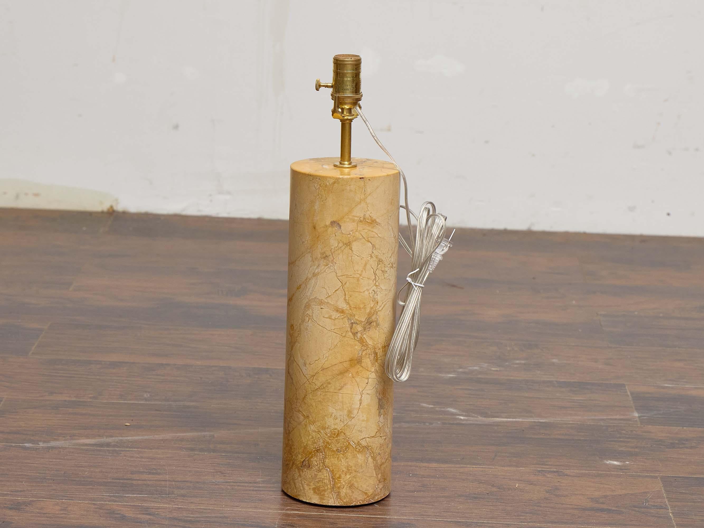 Una elegante lámpara de sobremesa italiana de mediados de siglo elaborada a partir de un único bloque cilíndrico de mármol, que muestra un armonioso equilibrio de forma y material natural. La piedra presenta cálidos tonos beige y crema, acentuados