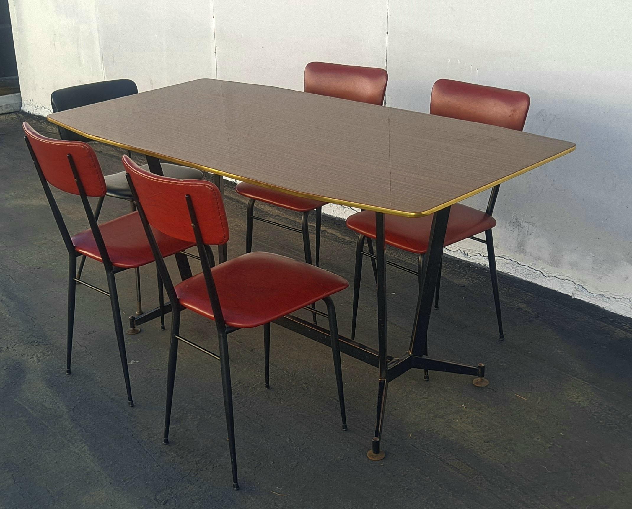 An original 1960's Italian table with 5 chairs. Iron base with brass boots and special Formica top. Overall, a unique dinning room set.