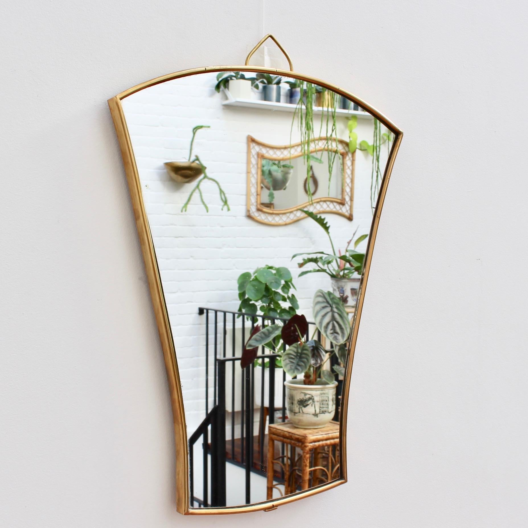 A midcentury Italian wall mirror with brass frame (circa 1950s). The small mirror is in the form of a folding fan. Classically elegant and distinctive in a modern Gio Ponti style. This mirror is in good vintage condition. There are some evident