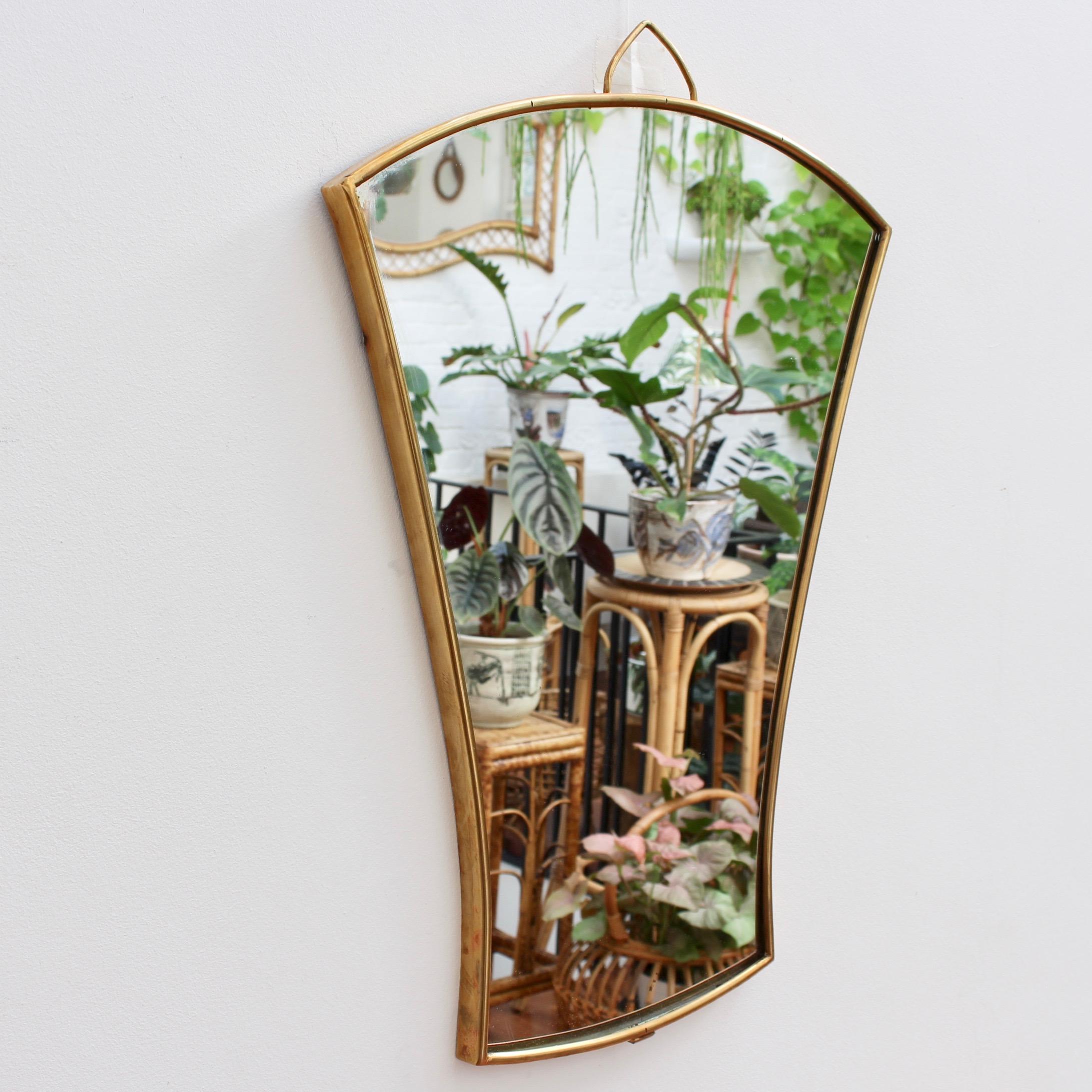 A midcentury Italian wall mirror with brass frame (circa 1950s). The small mirror is in the form of a folding fan. Classically elegant and distinctive in a modern Gio Ponti style. This mirror is in fair vintage condition. There are some evident
