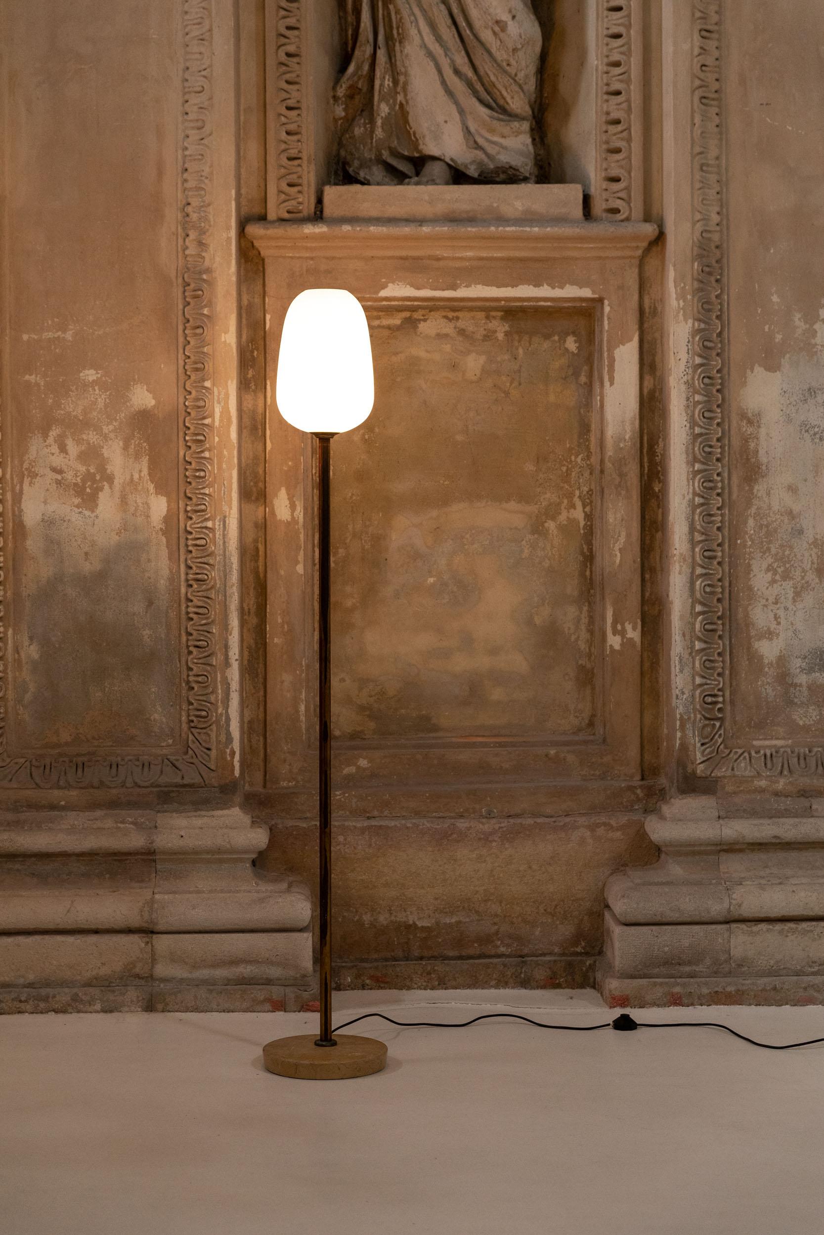 Stilnovo floor lamp, made of Opaline glass mounted on a golden brass structure with marble base.
Italy, 1950s.