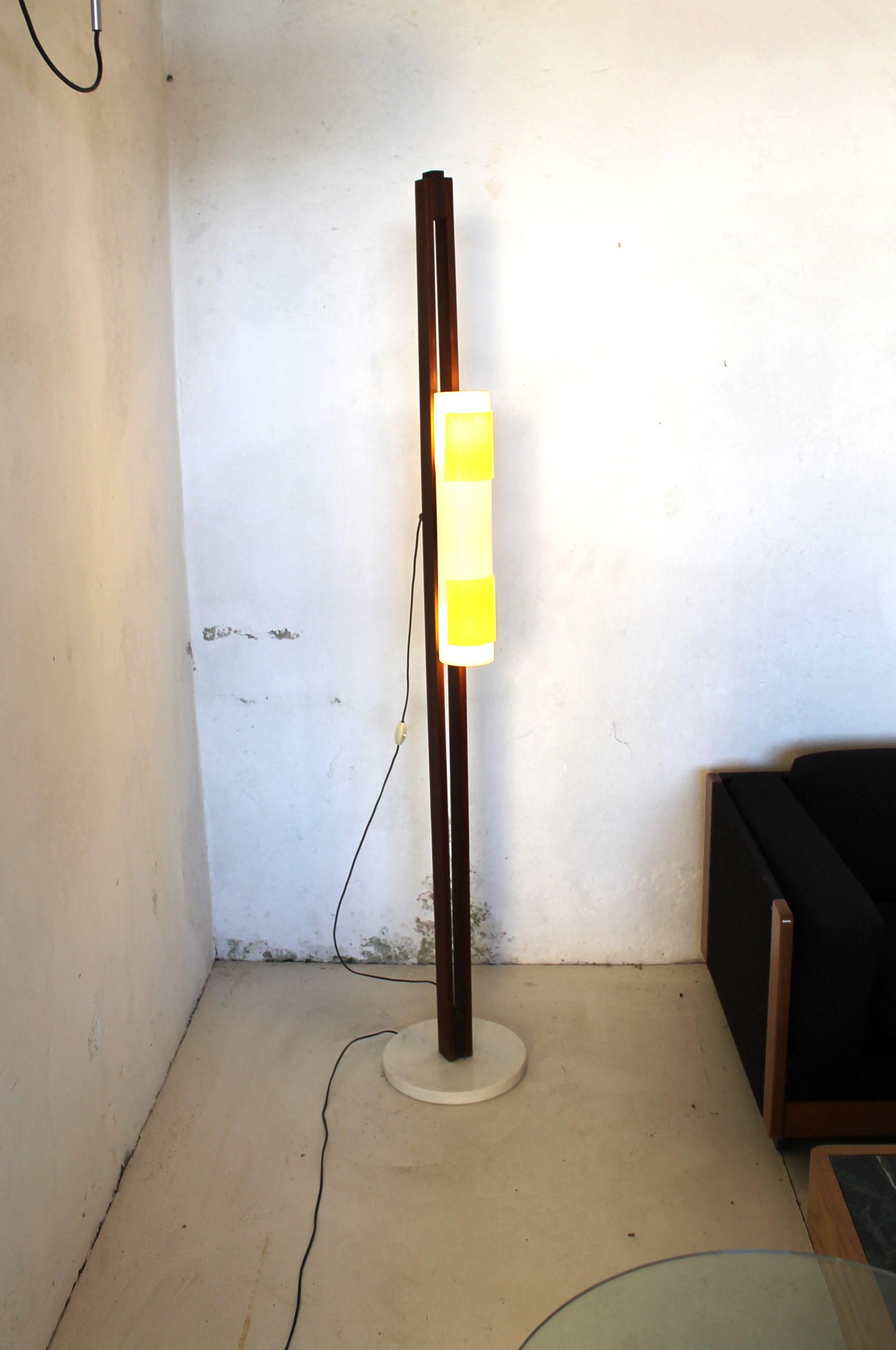 Italian Floor Lamp with white round marble base, opaline and yellow metacrylate diffuser flowing between two wooden rods.

This lamp is a fine example of the Italian production of the 60s, with references to the design of the architect Gino