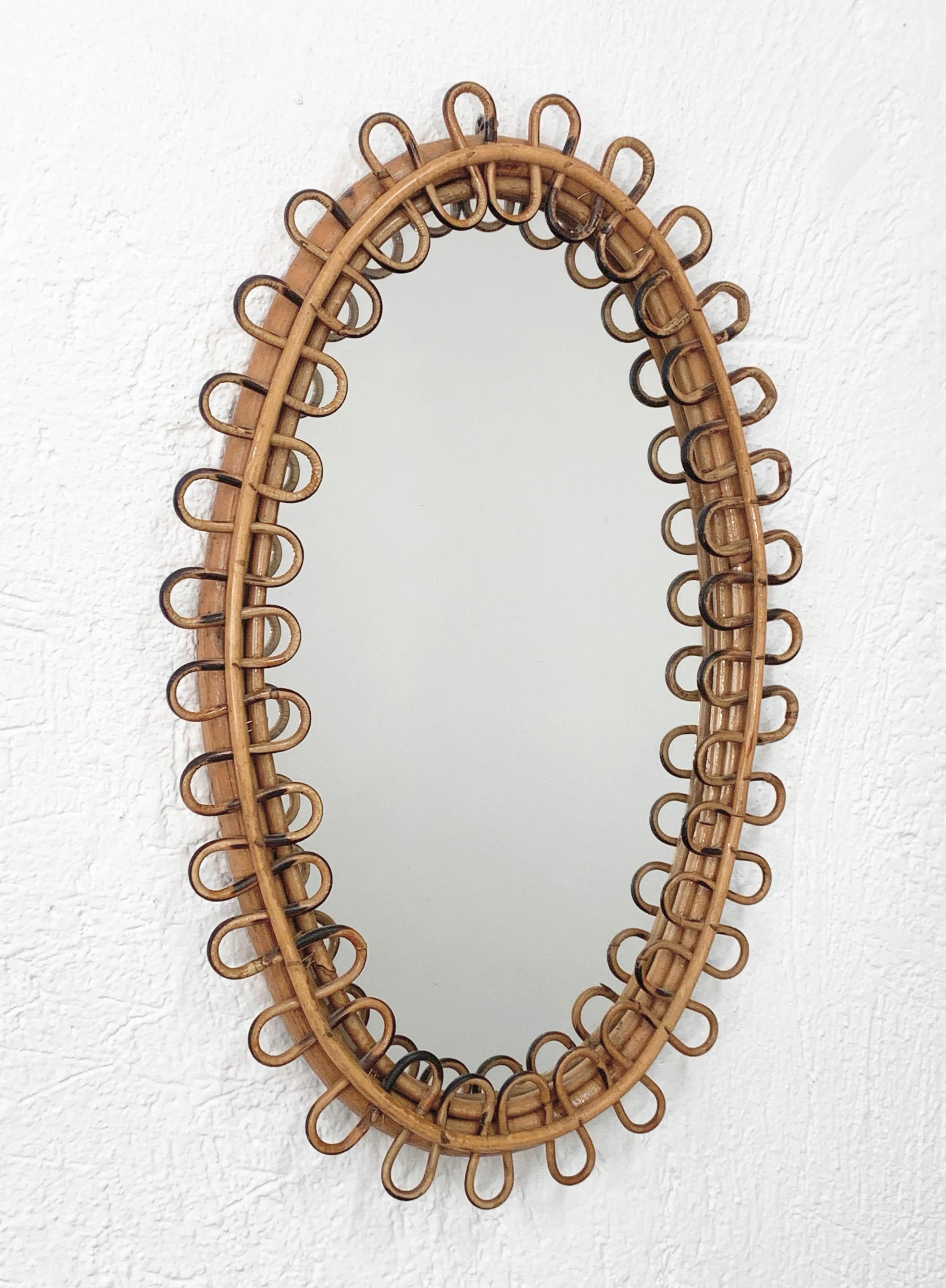 Amazing oval mirror with curved rattan beams and bamboo frame attributed to Franco Albini.

The item was produced in Italy during 1950s. This marvellous midcentury piece will enrich an entrance hall or living room.

Measurements (cm): 
height