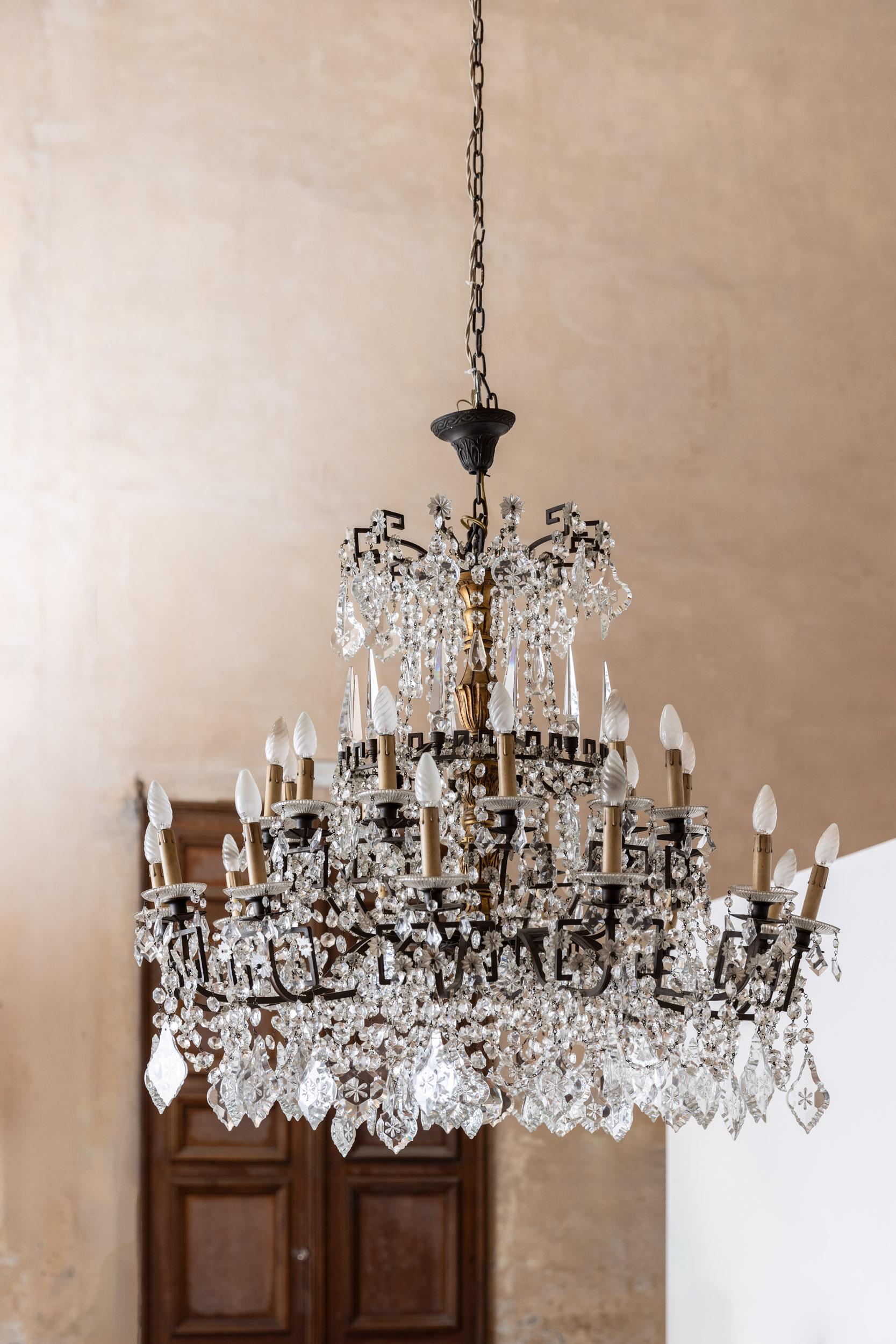 Midcentury large crystal chandelier with original iron structure. This chandelier is finely decorated with crystal flowers, large crystal drops and different size of crystal decoration.
Italy 1940