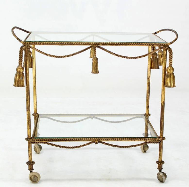 Wrought Iron Midcentury Italian Gold Gilt Metal Rope and Tassels Glass Top Bar Tea Cart Wheel For Sale