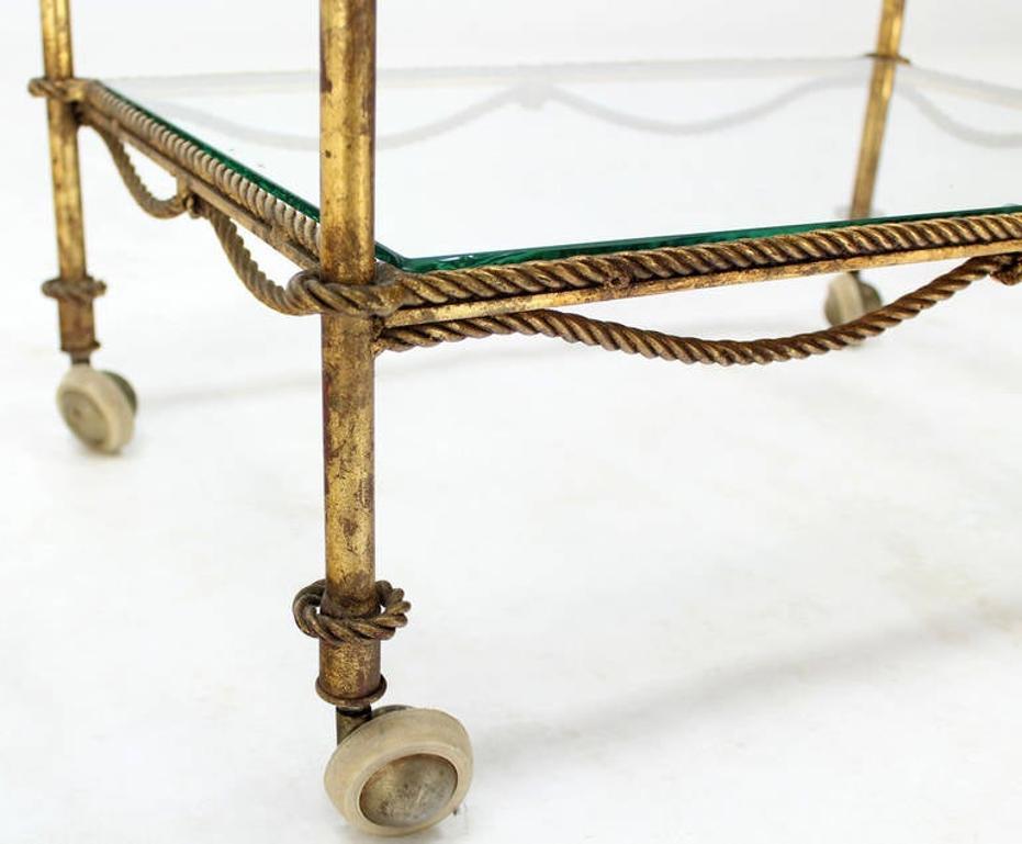 Hollywood Regency Midcentury Italian Gold Gilt Metal Rope and Tassels Glass Top Bar Tea Cart Wheel For Sale