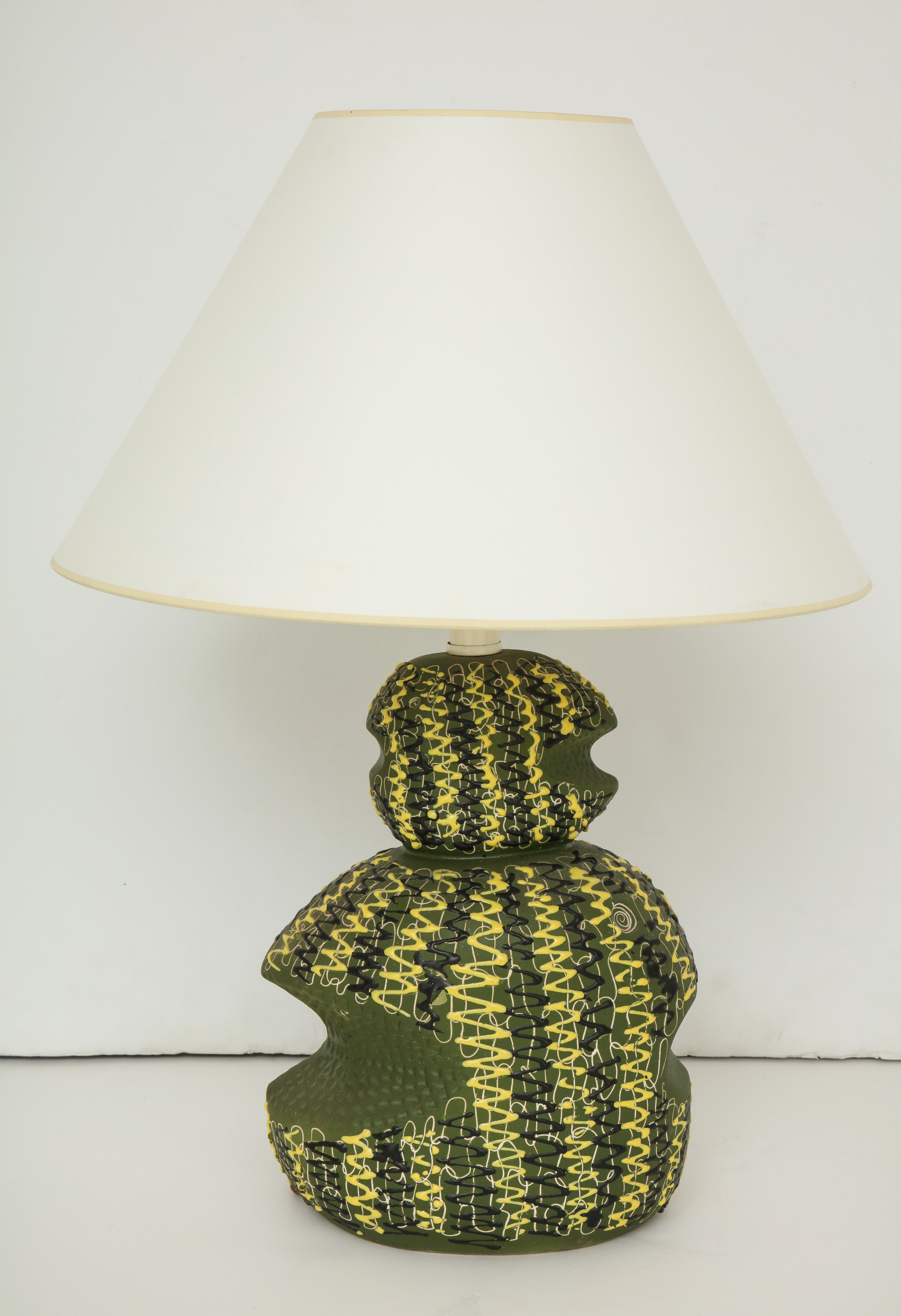 A vintage ceramic table lamp with a textured design in green, yellow and black. Italy, circa 1950. Includes paper shade.

Dimensions:
28 inches total H with shade
14 inches H to socket base / 12 inches H ceramic base only
9 inches L
6 inches