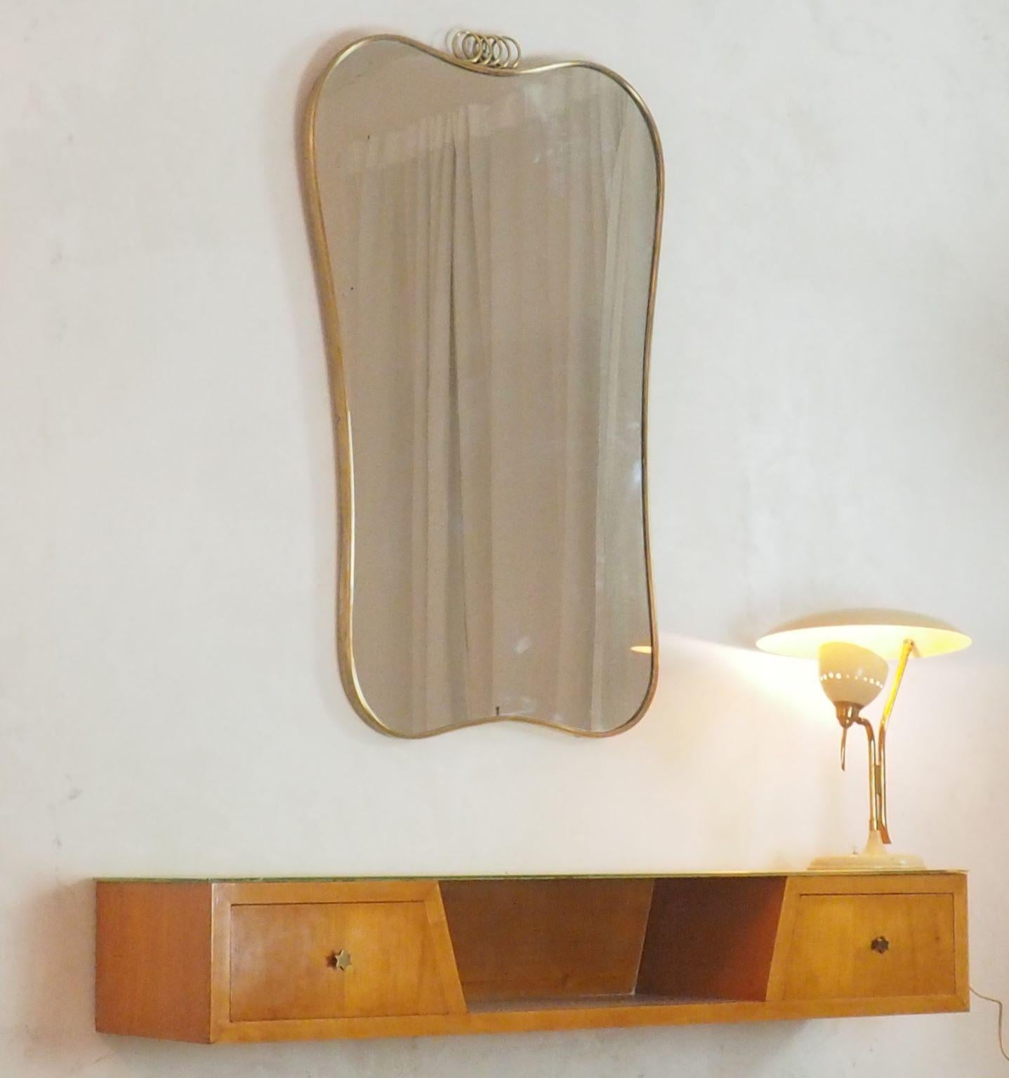 Italian large wall mirror, with curved brass frame and bevelled original mirror.
General good condition with original patina of the brass.
High quality of the thick brass frame.
Very Similar examples were designed by Gio Ponti in 1950s.
  