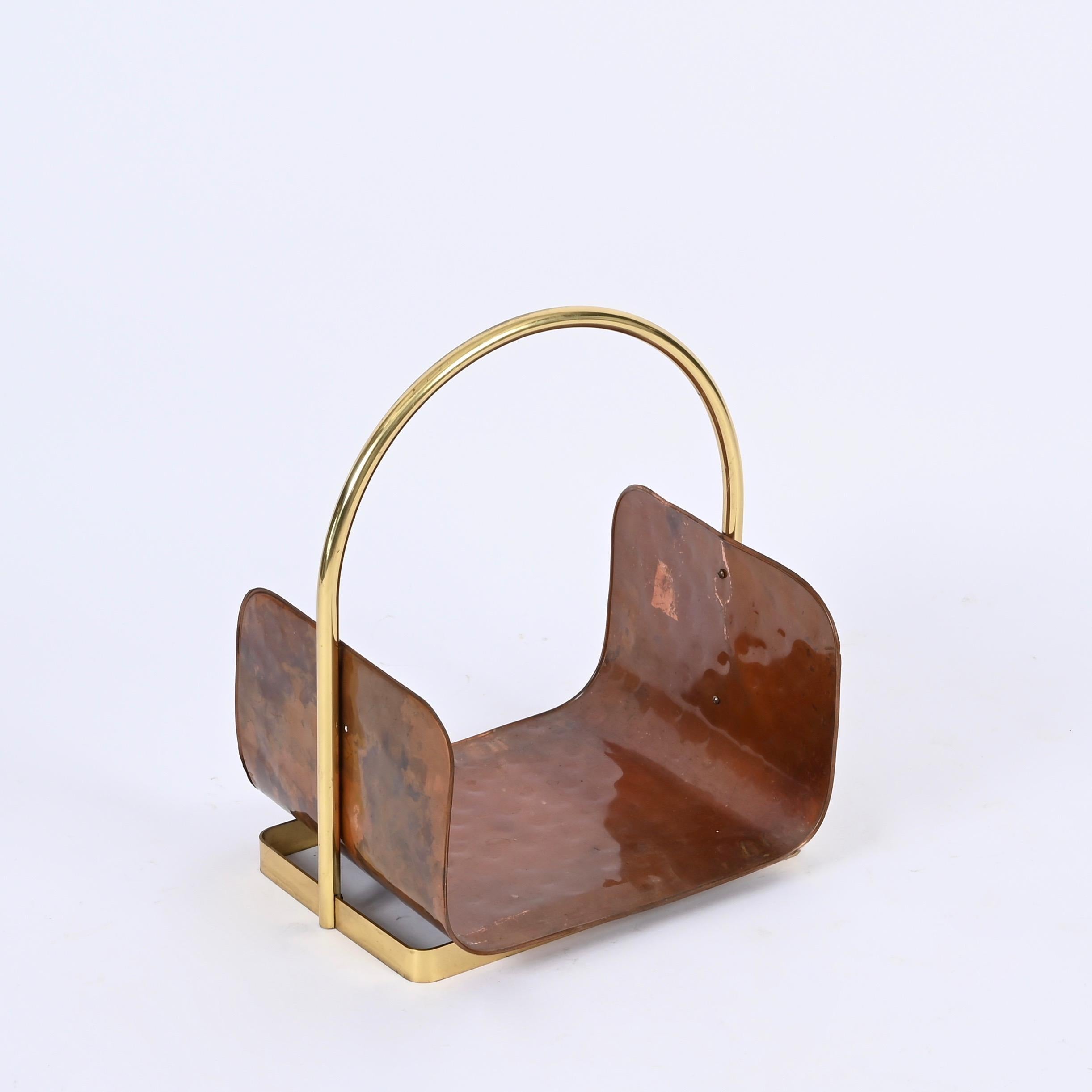 Gorgeous Italian magazine rack fully made in hammered brass with a solid brass handle. This stylish rack was made in Italy during the 1970s. 

This unique magazine stand has a curved U-shaped tray in hammered copper which is enriched by a gilt brass