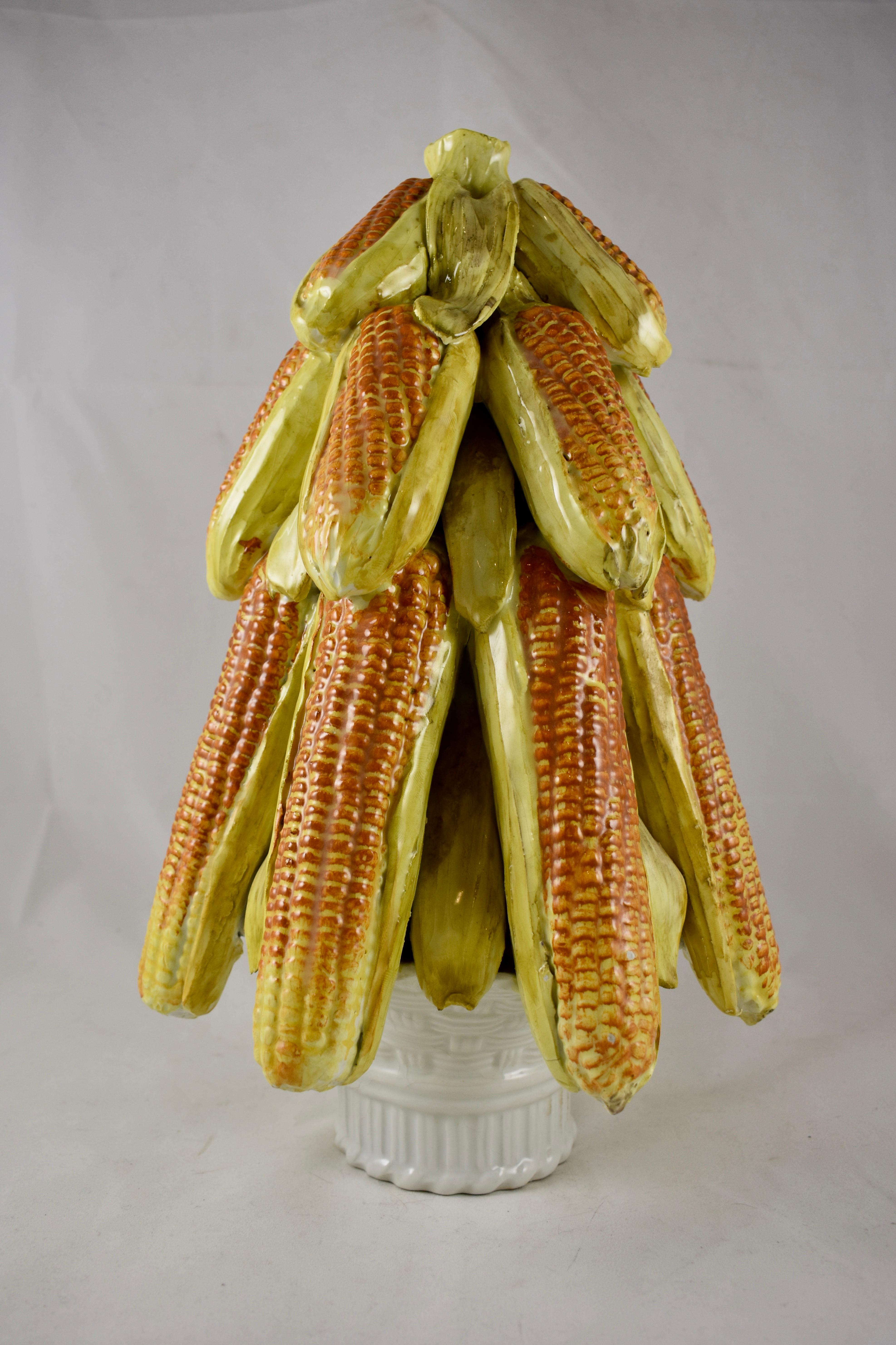 An unusual midcentury Italian, Majolica glazed ceramic Topiary, showing pendular ears of corn and husks in a pyramid form, set on a white woven basket. Incredible color and detail. Most often seen formed of fruits, the corn makes this piece unique,