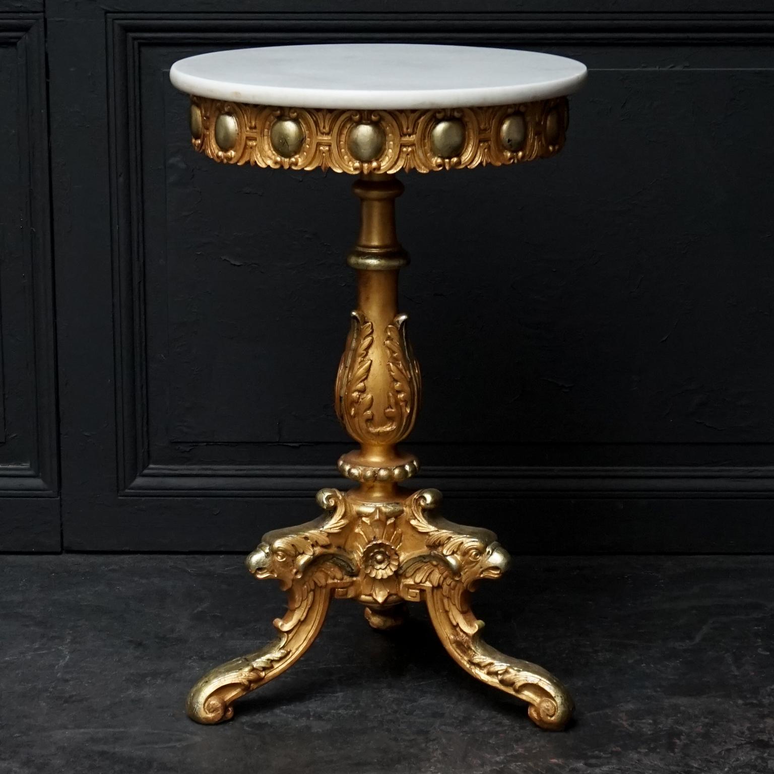 Mid-20th century Italian end or side table with round white marble-top and carved giltwood leg, ending in three legs adorned with carved and gilded eagle heads.

The leg is plaster on carved wood, two-tone gilt, with gold paint and with gold