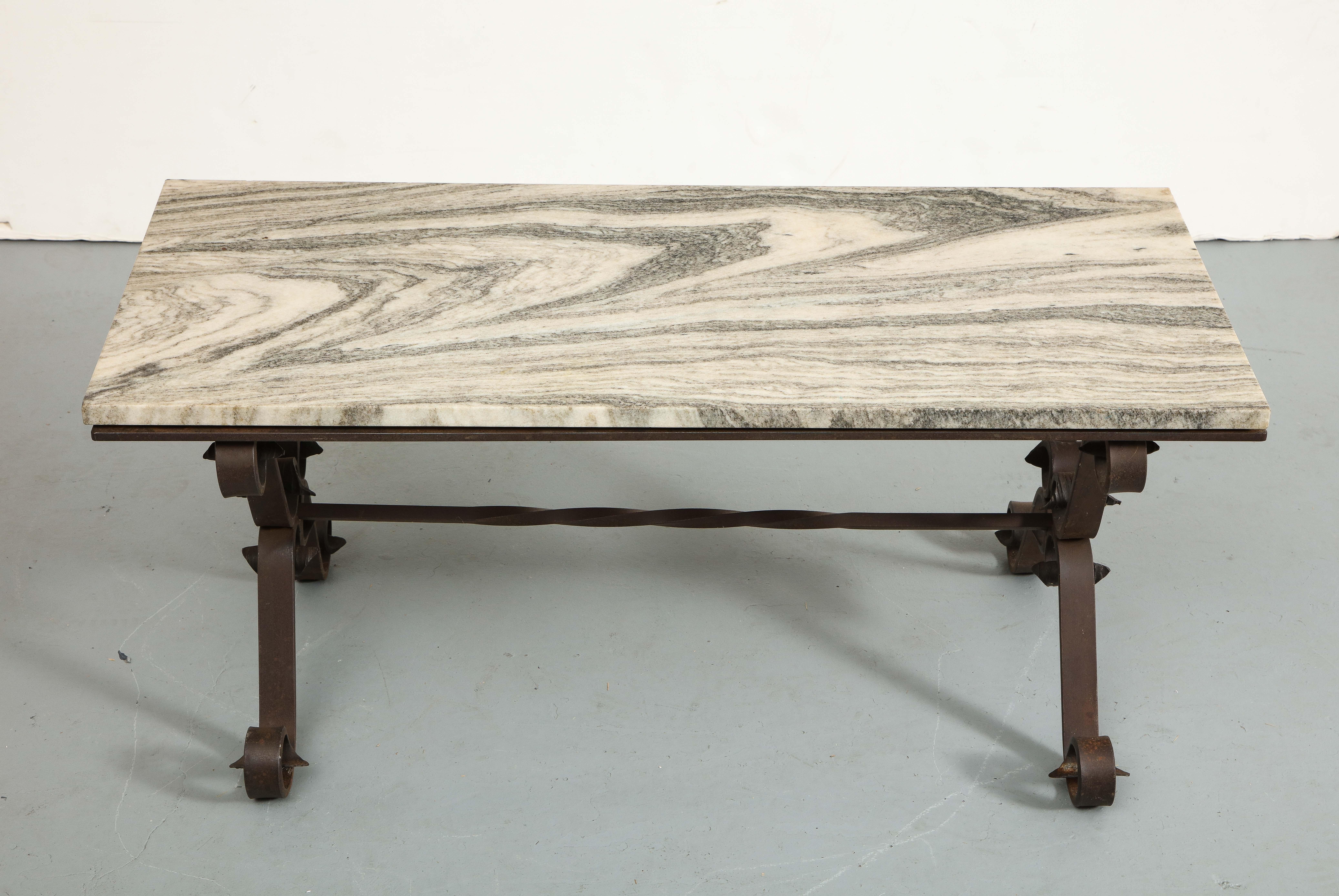 Midcentury Italian cocktail table with a cast iron base, curving scroll feet, and rectangular marble top.