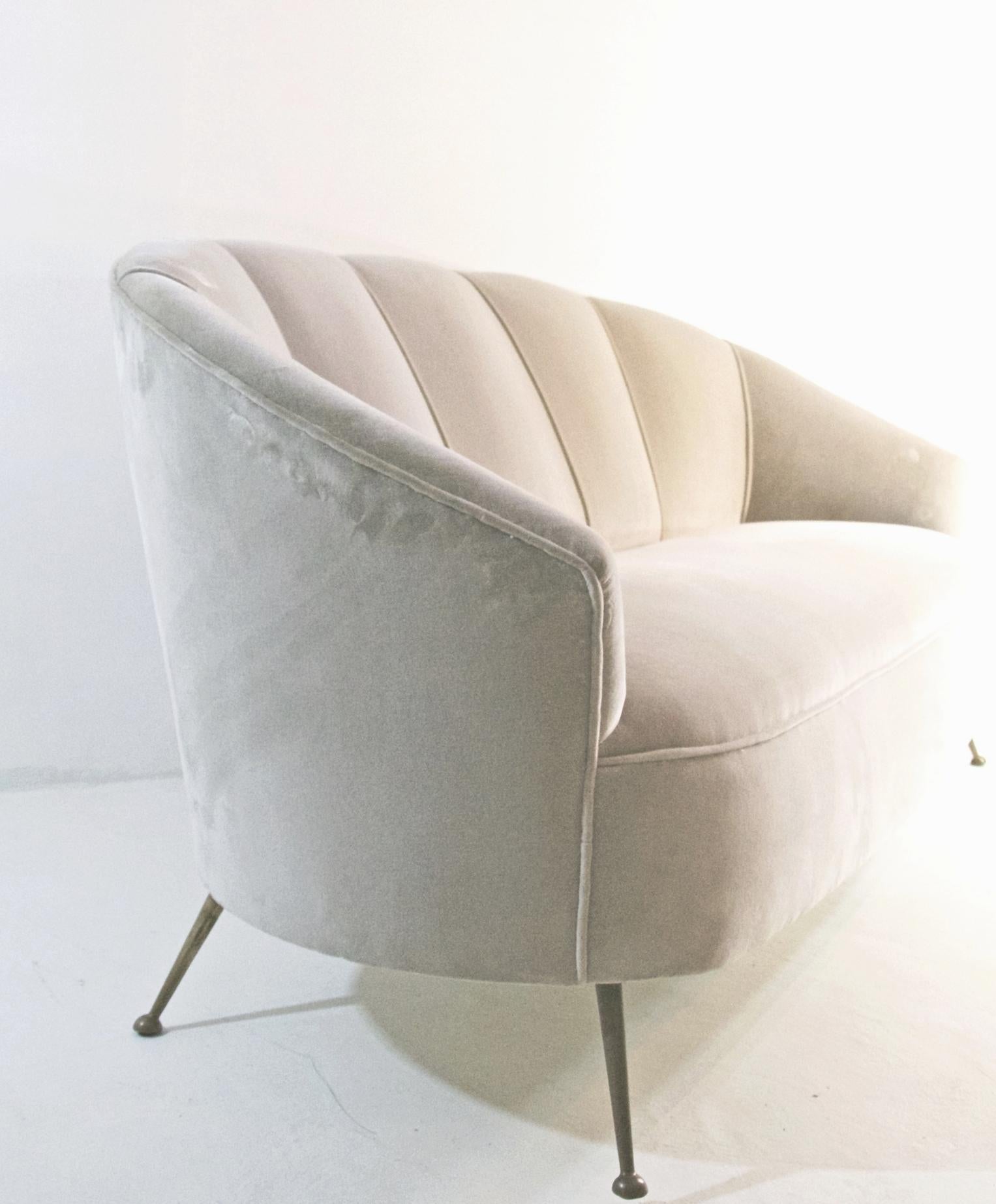 Elegant sofa with brass spider legs in a Classic clam design. This piece has recently been professionally reupholstered in a quality Italian velvet fabric.