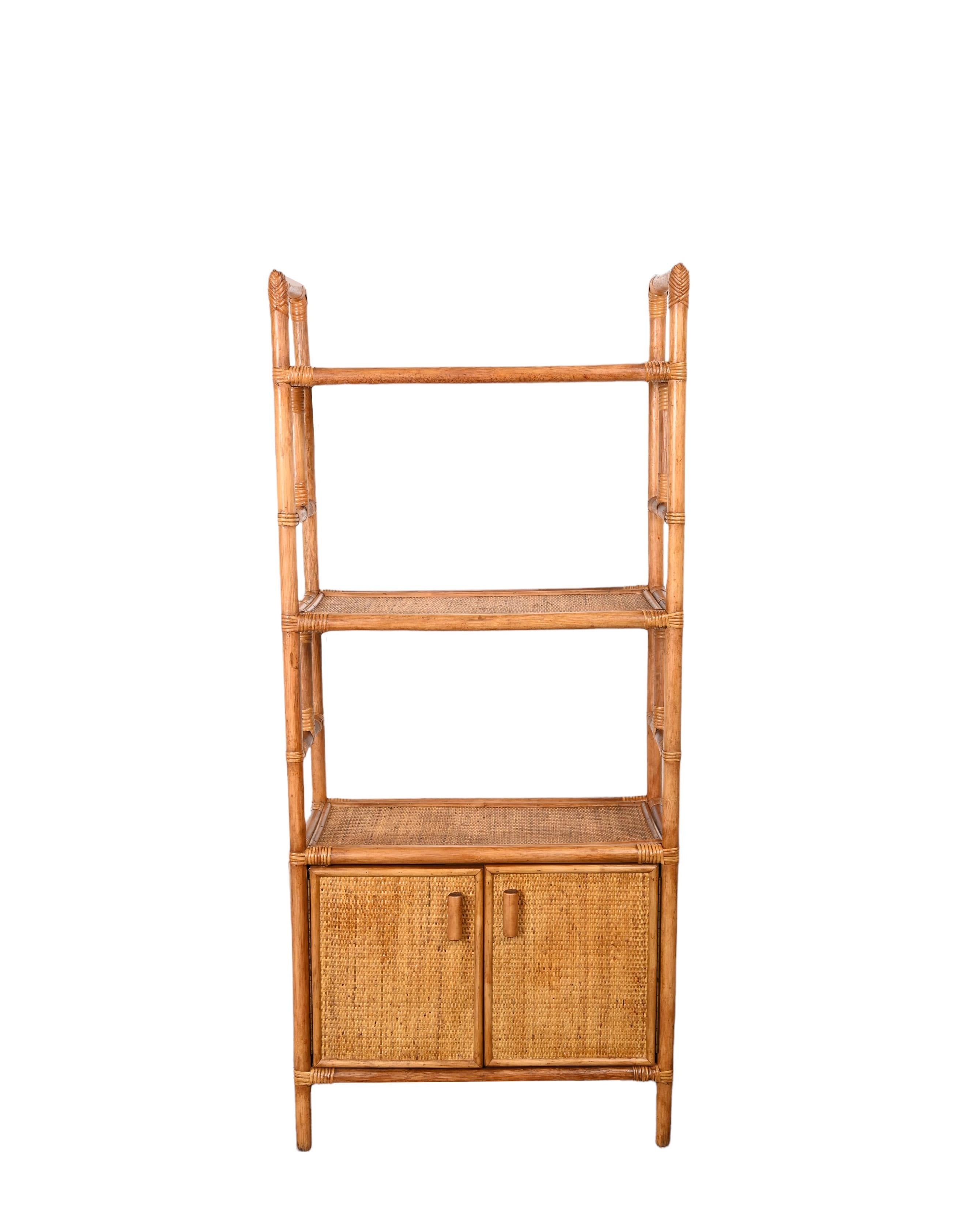 Amazing midcentury modern rattan and bamboo bookcase with doors. This fantastic piece was designed in Italy during the 1970s.

This bookcase is very capacious, as it has three large shelves on the top part and a large section enclosed between two