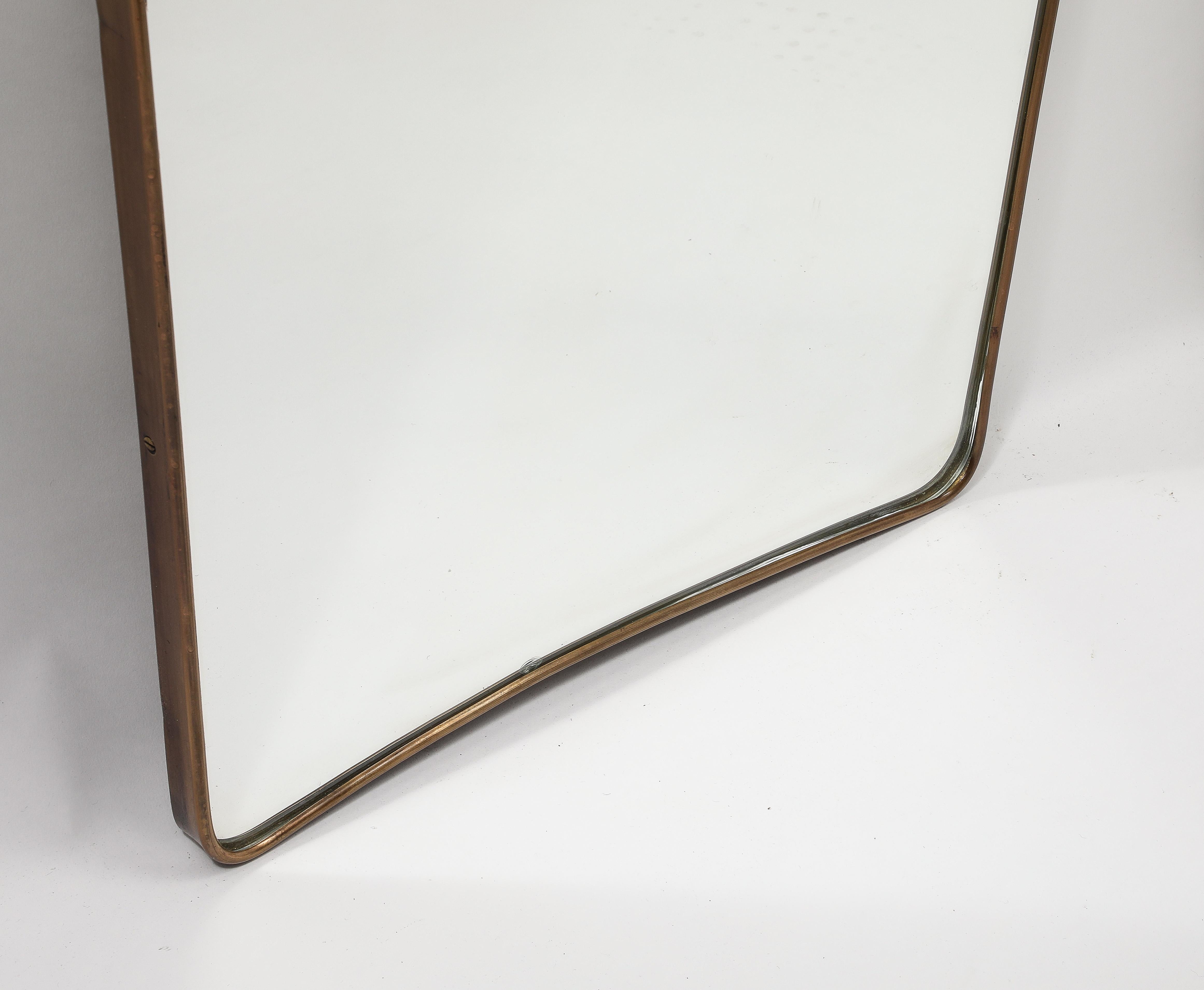 1950s Italian modernist pair of grand scale wall mirrors consisting of shaped brass frames with gently arched tops and rounded corners which taper towards the bottom. These chic pair of mirrors are truly an iconic Italian midcentury brass mirror