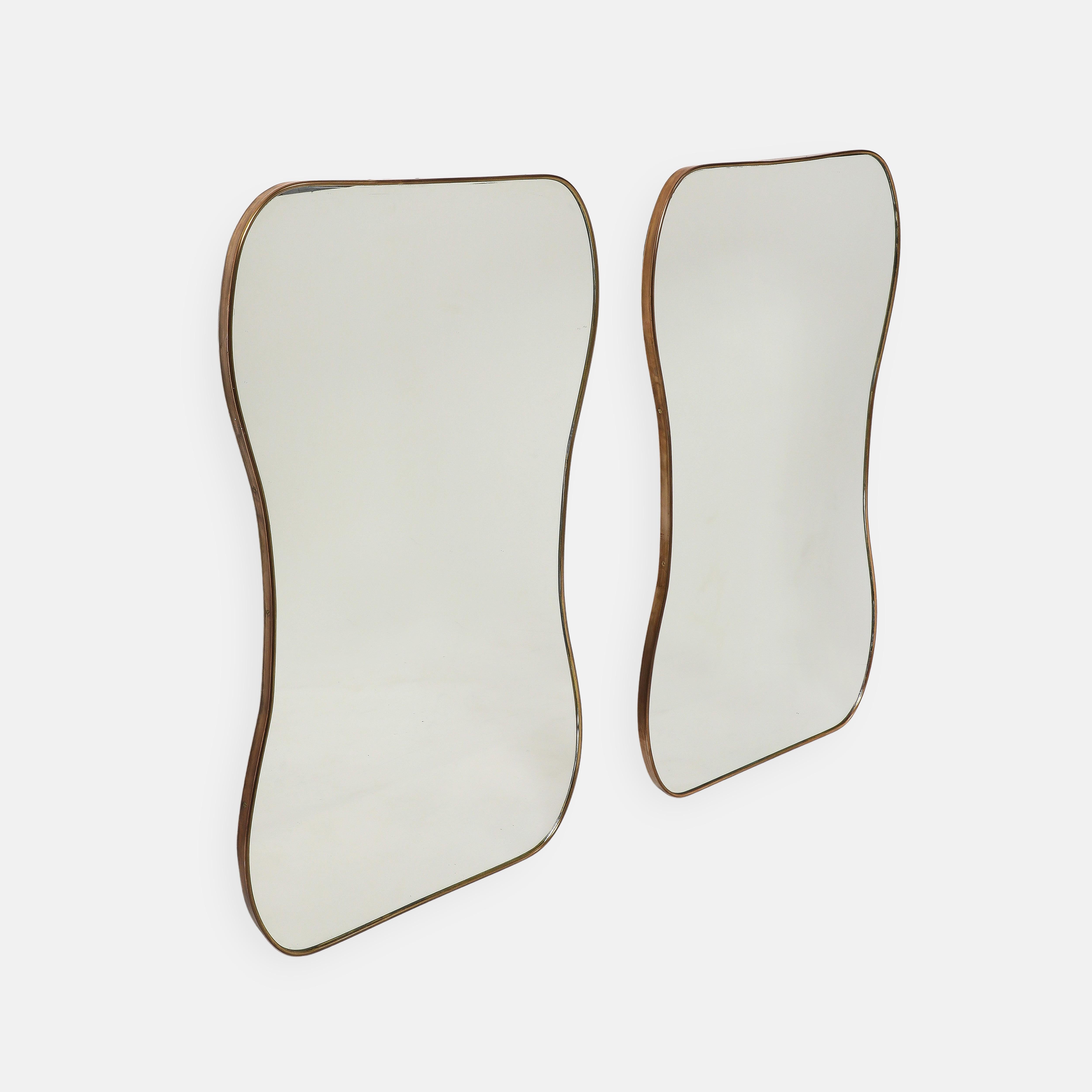 Paire de miroirs muraux en laiton en forme de sablier, Italie du milieu du siècle dernier, années 1950. Ces miroirs originaux de la période du milieu du siècle ont une belle forme organique incurvée et une belle patine riche sur le laiton.  Cette