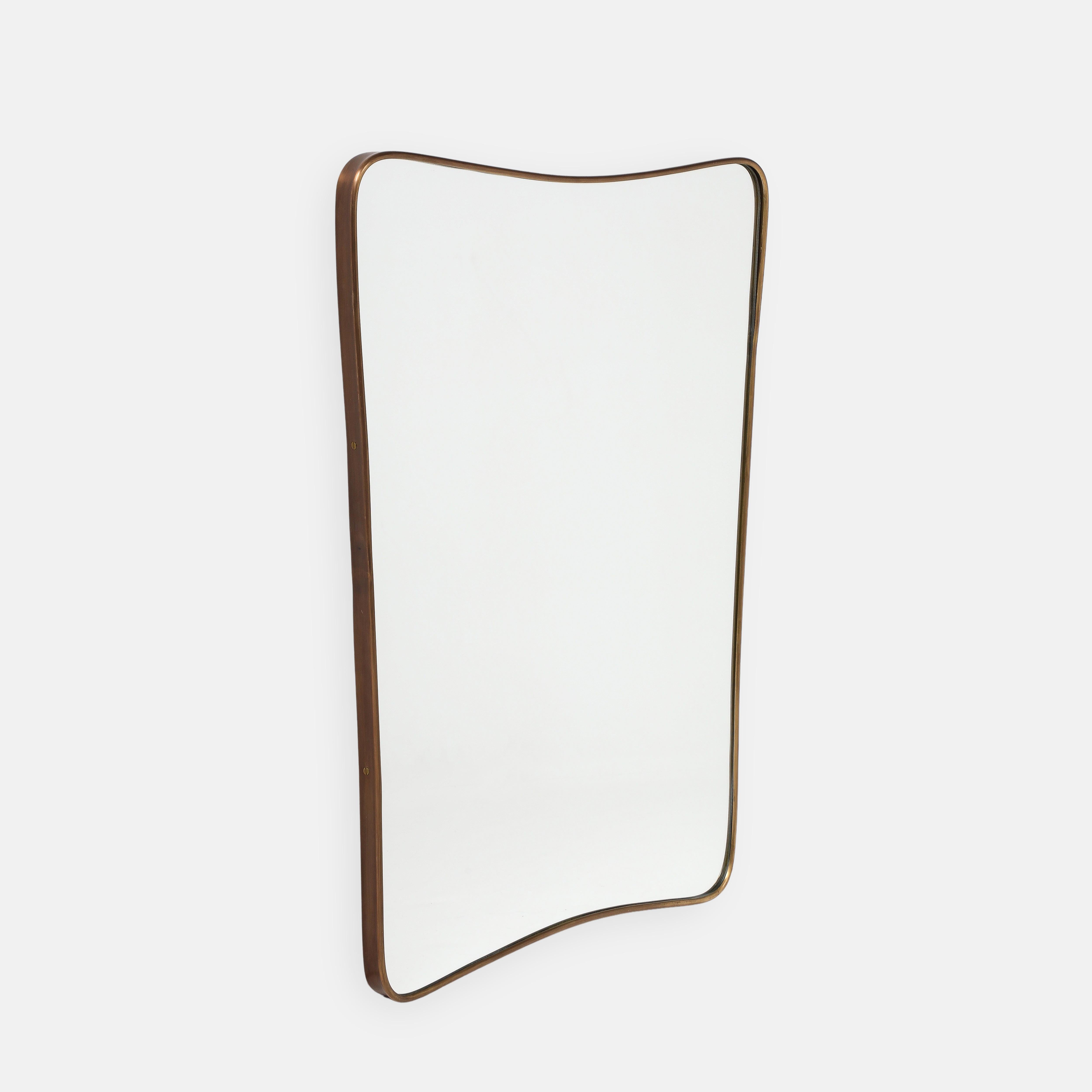 1950s Italian modernist pair of wall mirrors consisting of shaped brass frames with gently arched tops and rounded corners which taper towards the bottom with wood backings. This chic original pair of mirrors is truly an iconic Italian midcentury