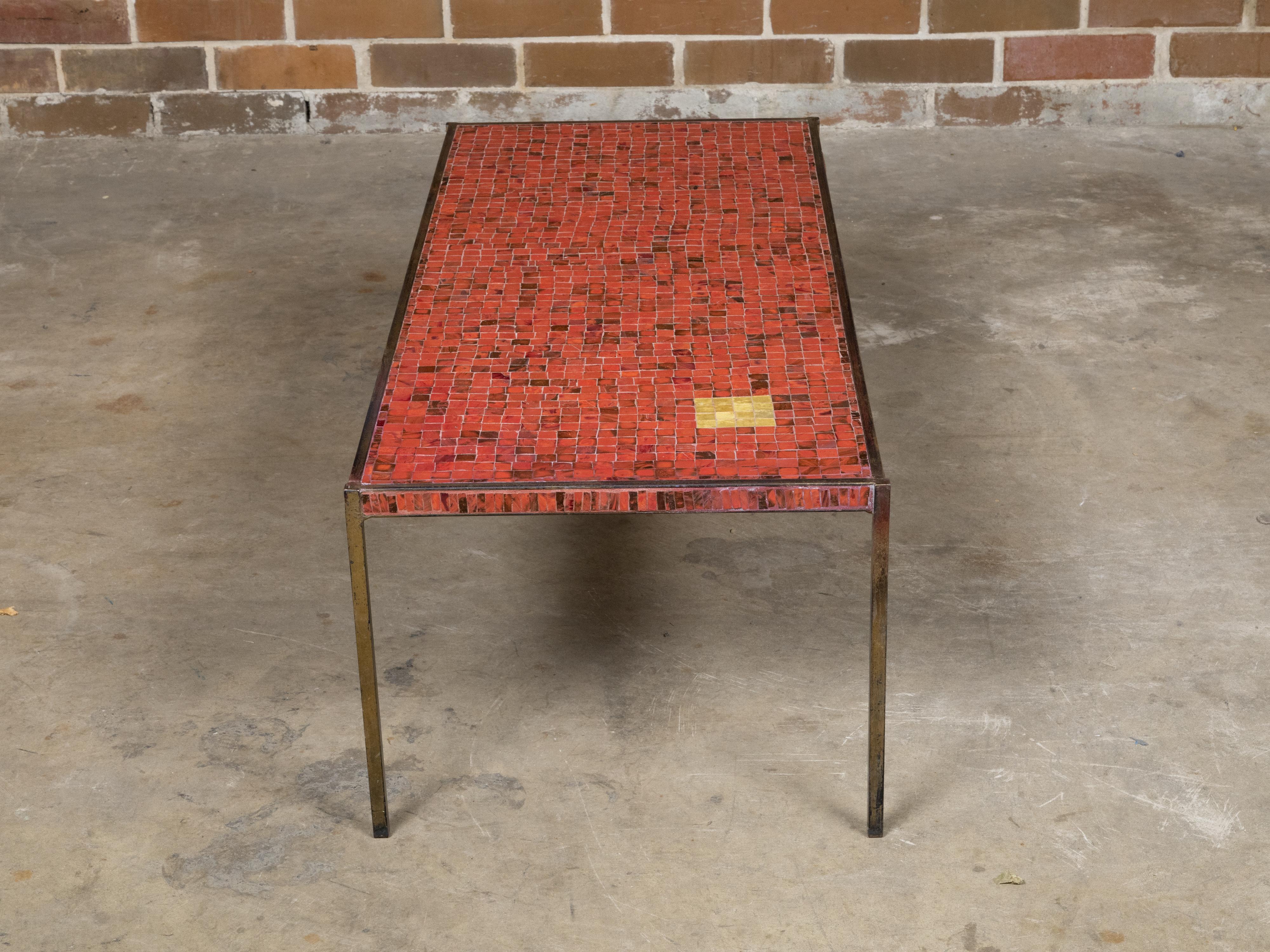An Italian Midcentury mosaic coffee table with iron base and red glass tile style top. This Italian Midcentury mosaic coffee table embodies the vibrant essence and artistic flair of the mid-20th century. It stands out with its slender gilt iron