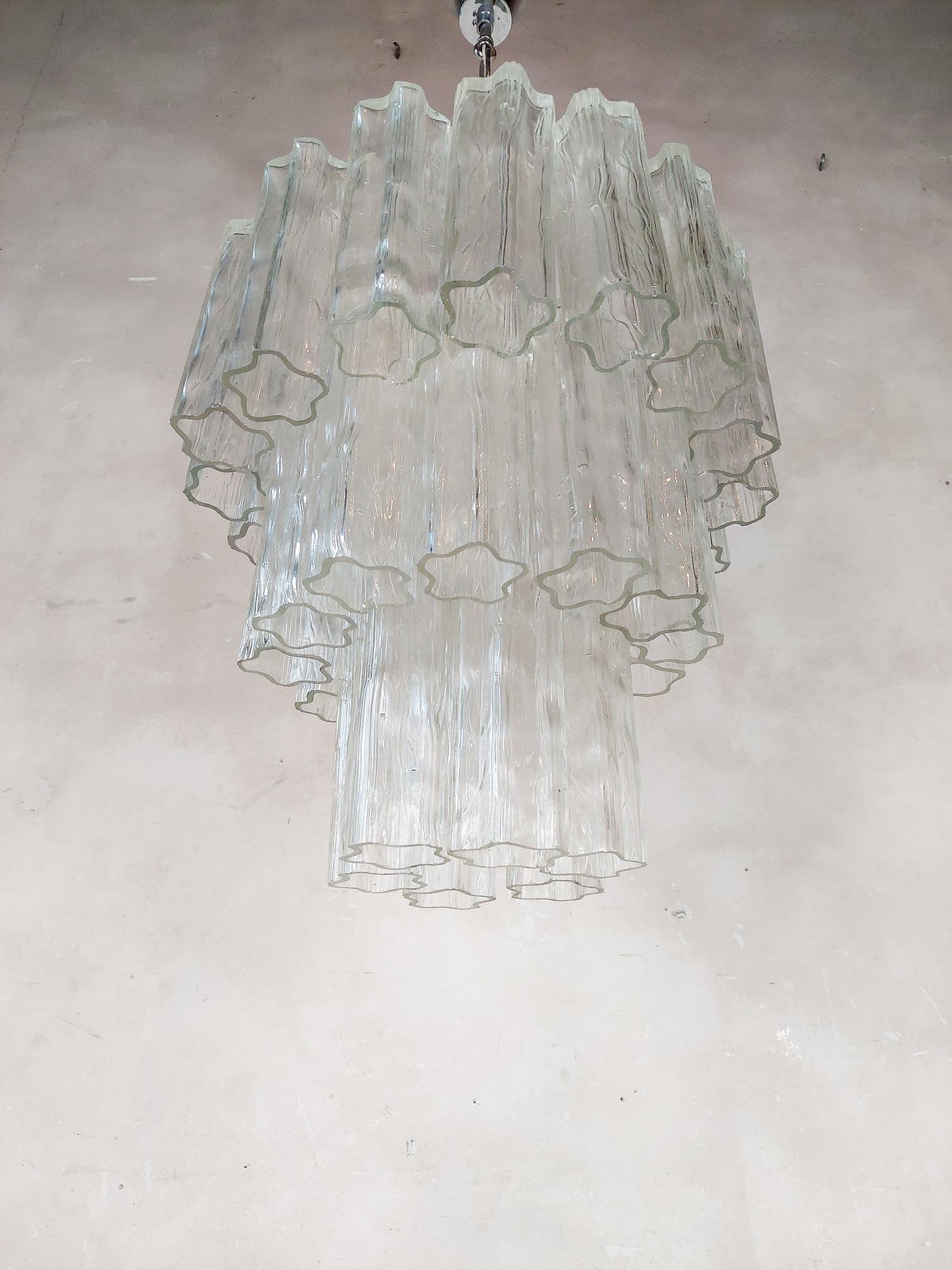 Italienischer Murano-Glaskronleuchter Tronchi von Venini, Mitte des Jahrhunderts.
Diese Hängelampe im Vintage-Stil besteht aus Elementen aus mundgeblasenen Glasröhren oder Eiszapfen, die wegen ihrer Form, die einer Rinde ähnelt, 