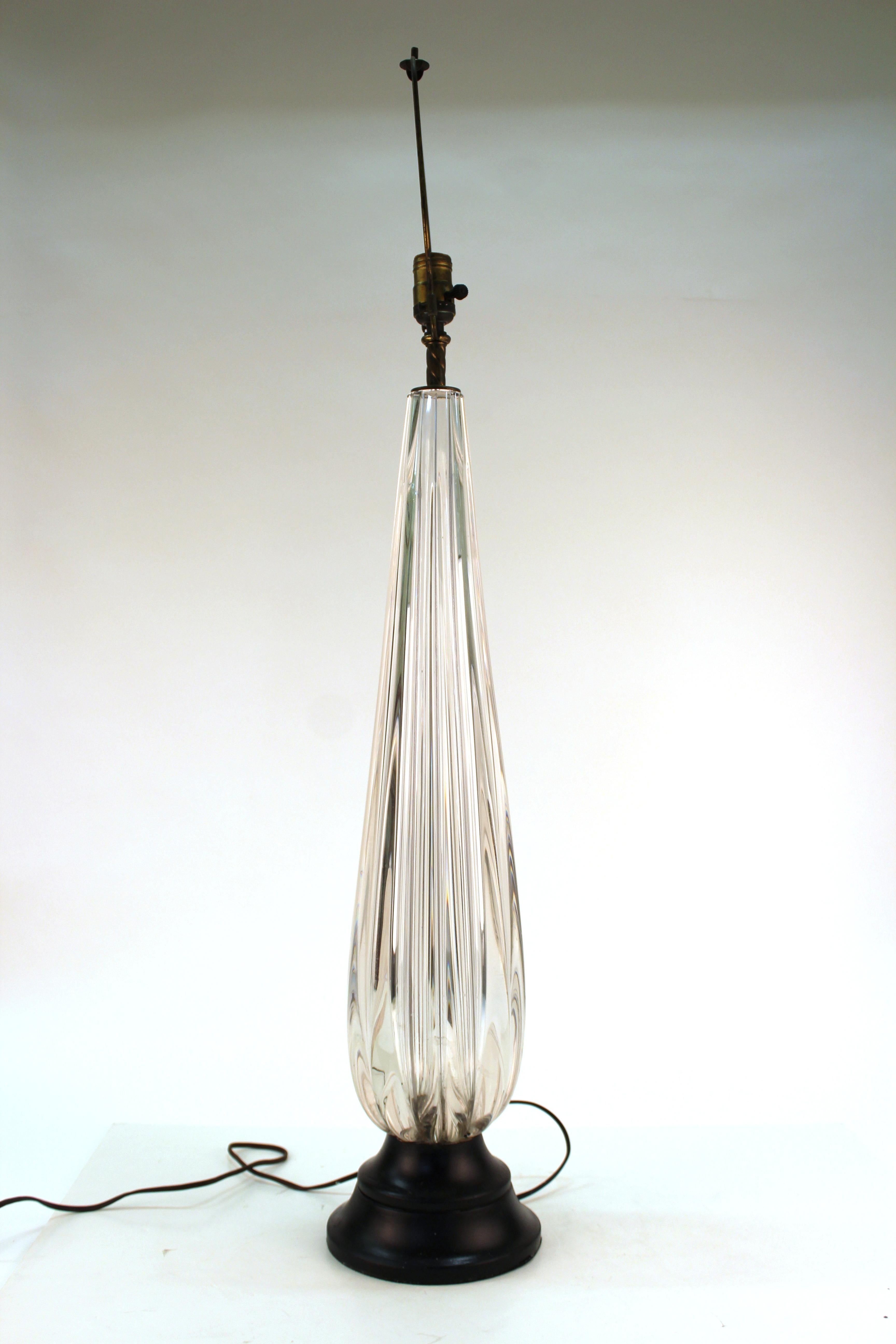 Mid-Century Modern Italian Murano glass table lamp with fluted clear glass atop a circular ebonized wood base. The piece was made during the mid-20th century in Italy and is in great vintage condition with some age-appropriate wear to the bottom of