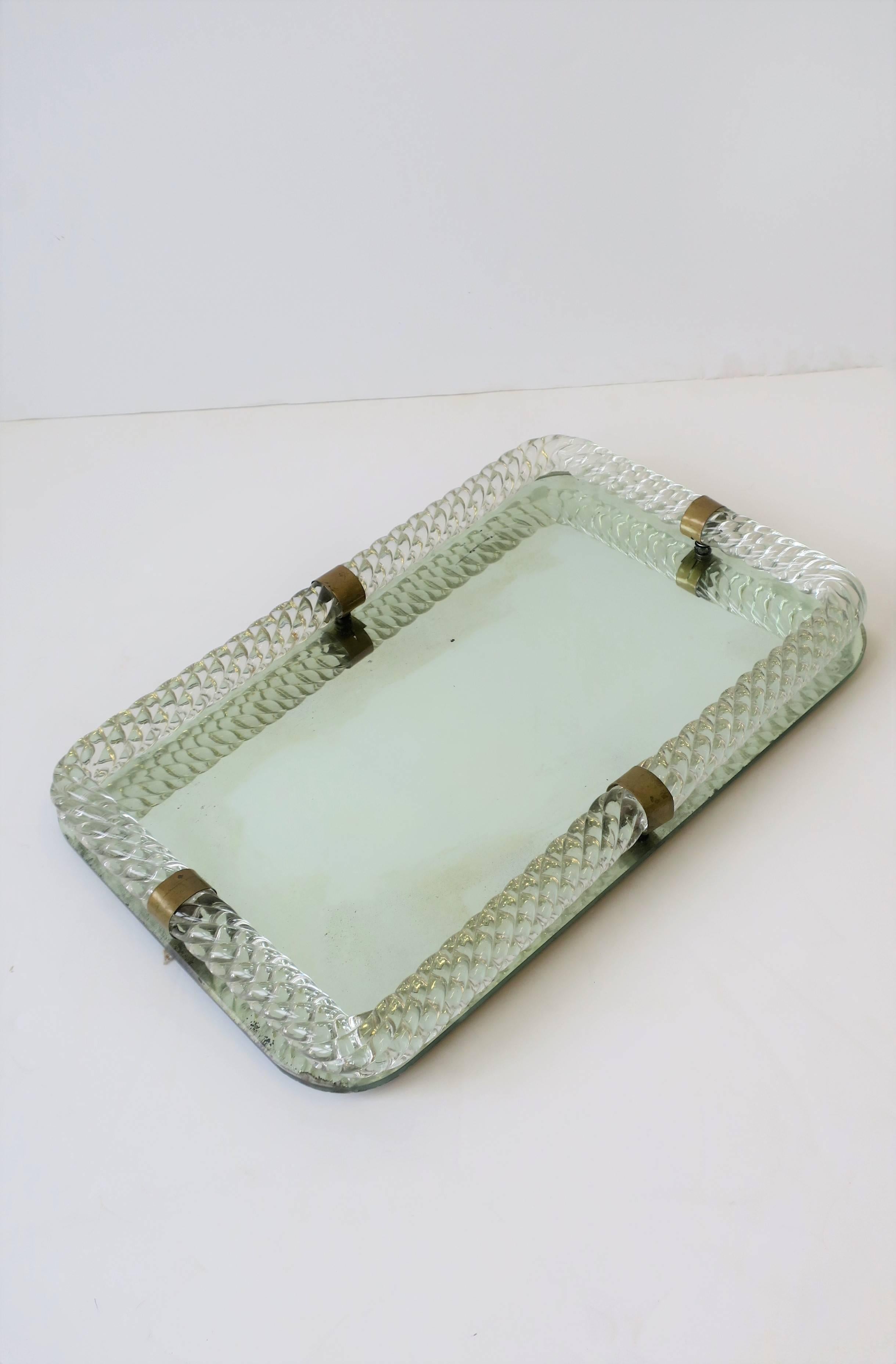 A beautiful Italian Murano art glass and mirror vanity tray with brass loop detailing, in the style of Vinini, circa Mid-20th Century, Italy.

Tray measures: 16 in. W x 10 in. D x 1.75 in. H


