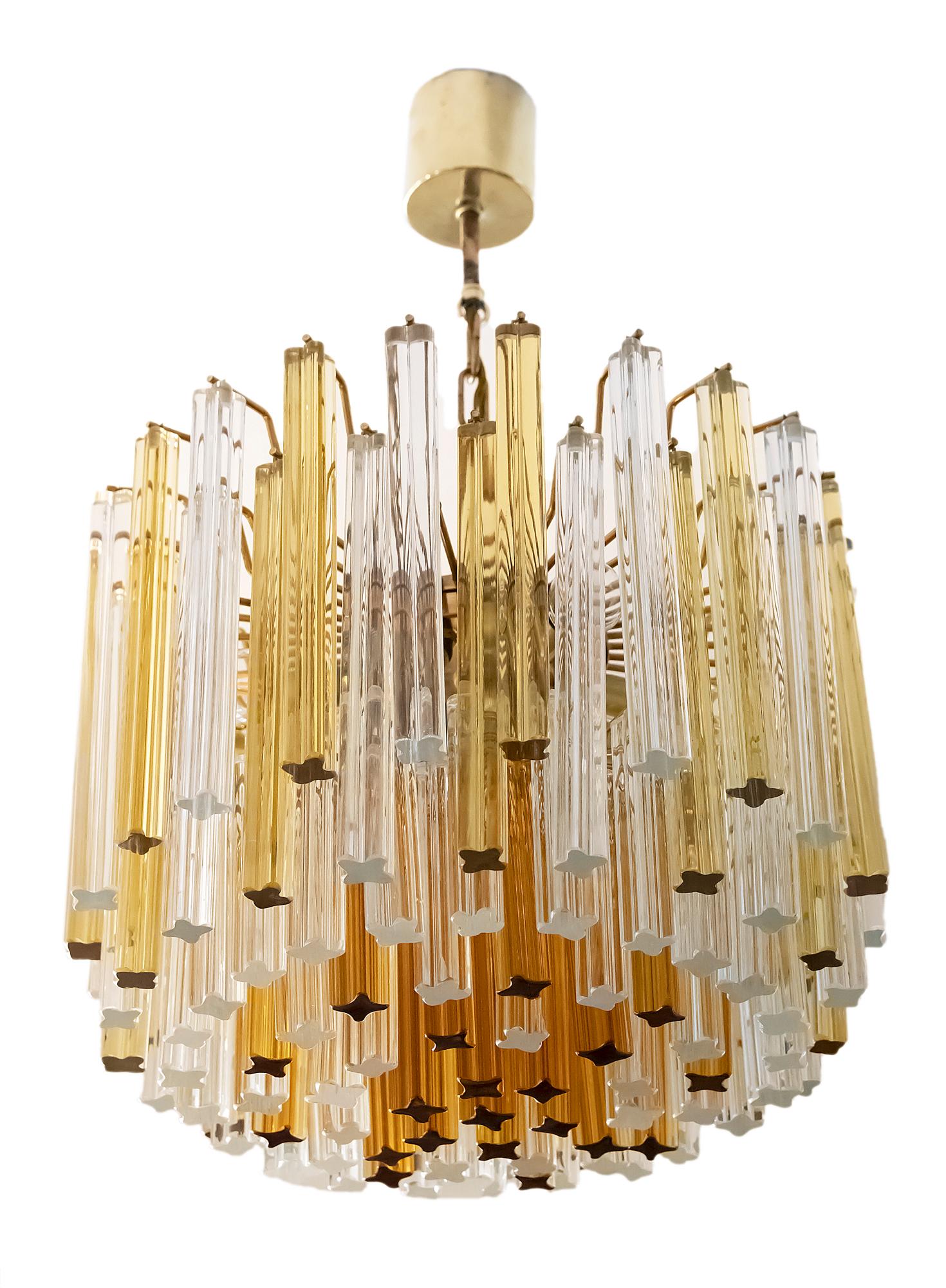 Midcentury Italian chandelier is made of metal base and solid clear, yellow and ambra colors Murano glass. It is very heavy. Chandelier includes 8 pcs. of E27 bulbs.